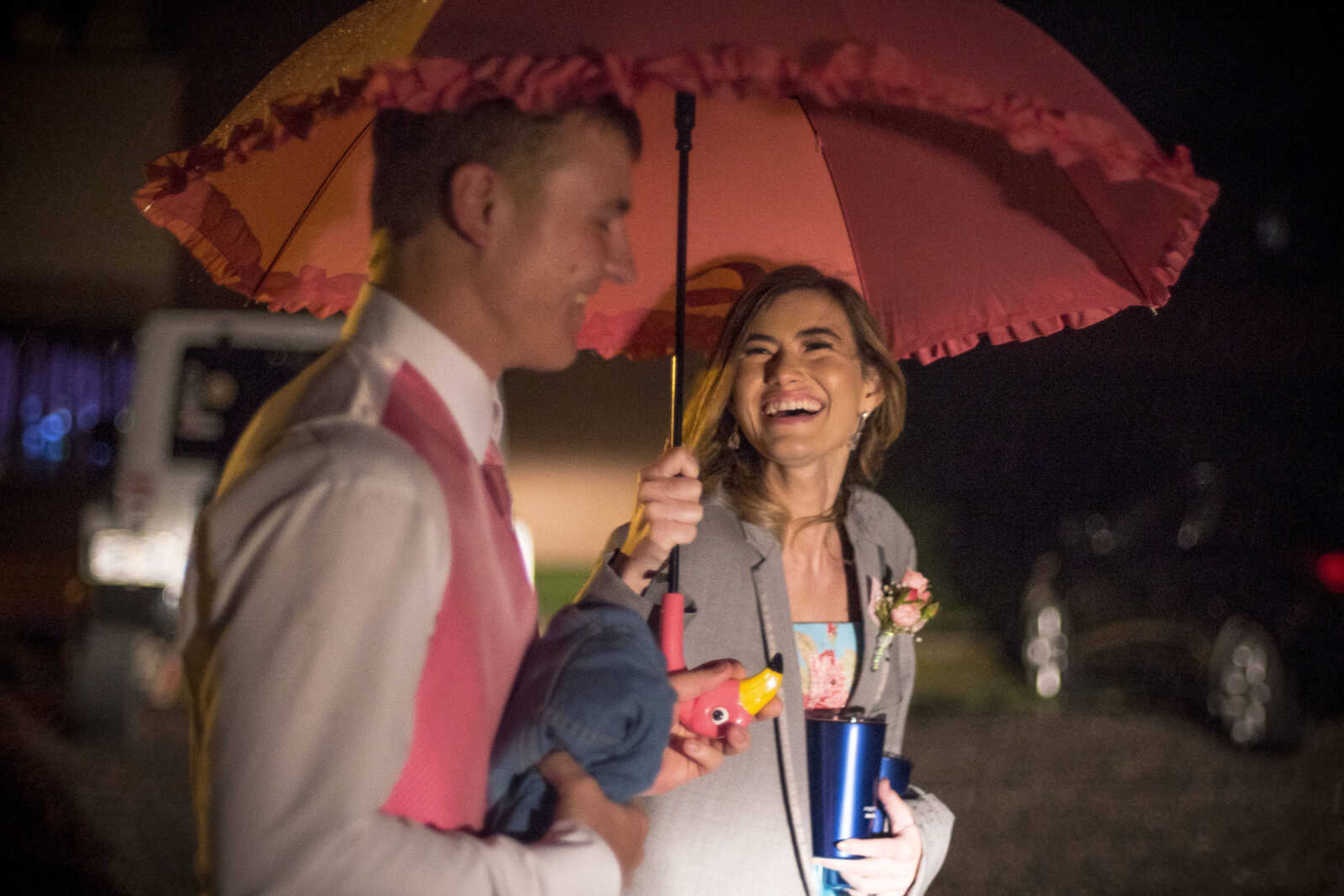 Sophie Thompson smiles at Drew Glueck as the two make their way to Glueck's truck through the rain after the Oak Ridge Prom Saturday, April 13, 2019, at the Jackson Elks Lodge in Jackson.