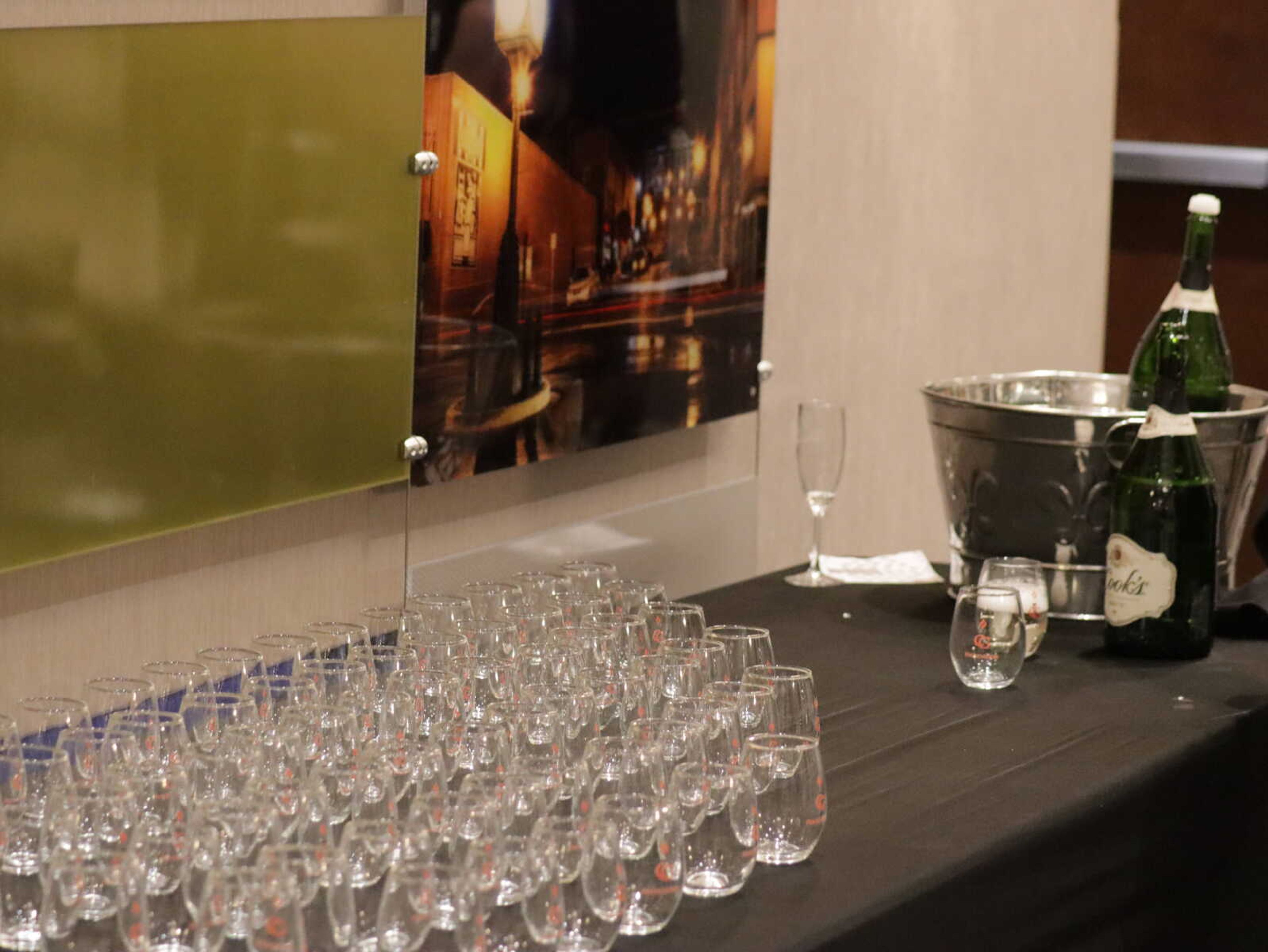 A table set up just outside the ballroom with a champagne bucket and glasses.