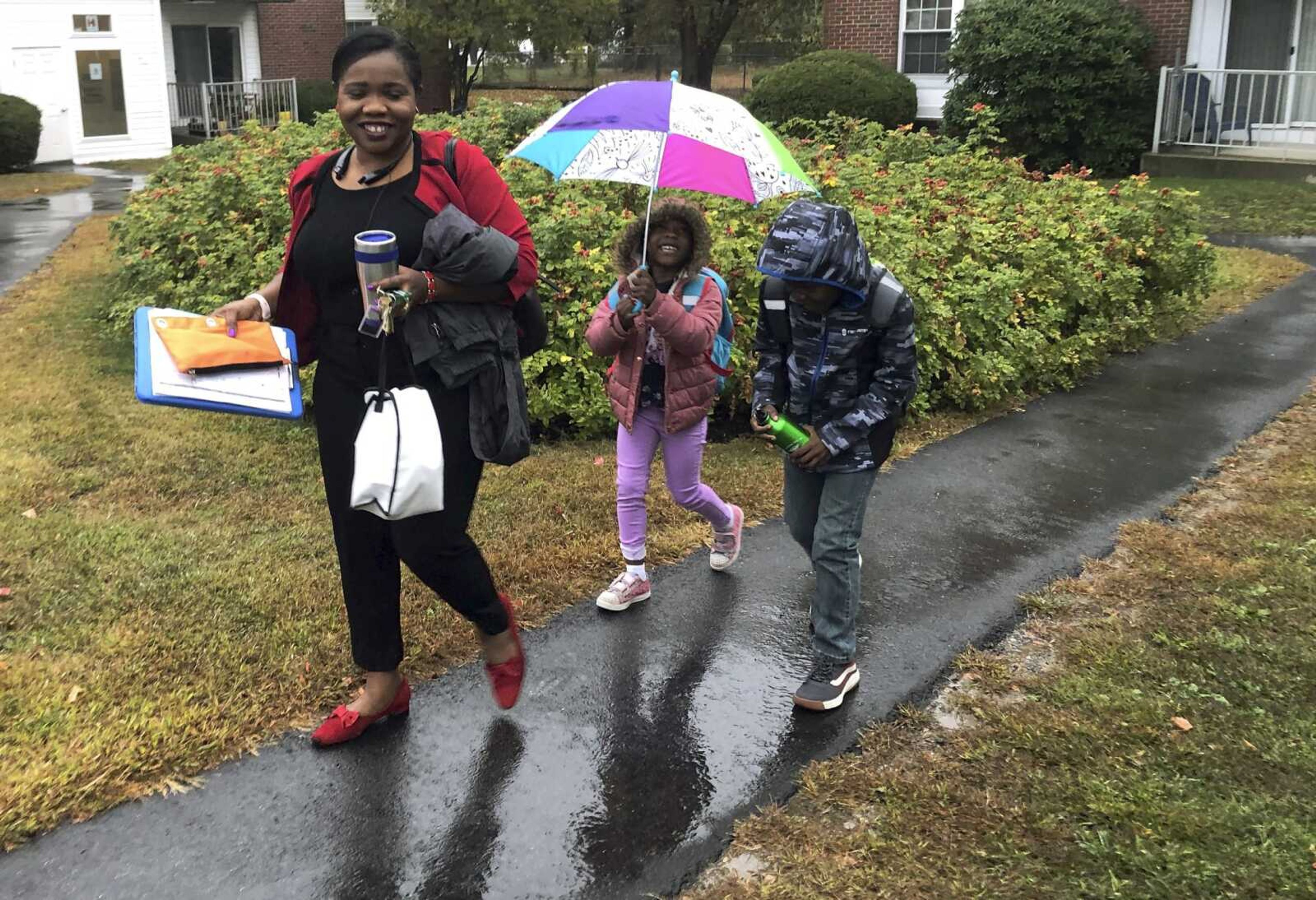 Betty Kabbashi, a medical interpreter, takes her children, Roda, 5, center, and Richie, 7, to school Tuesday in South Portland, Maine. Kabbashi, who was a dentist in South Sudan, disagrees with President Donald Trump's plan to further cut refugee quotas.