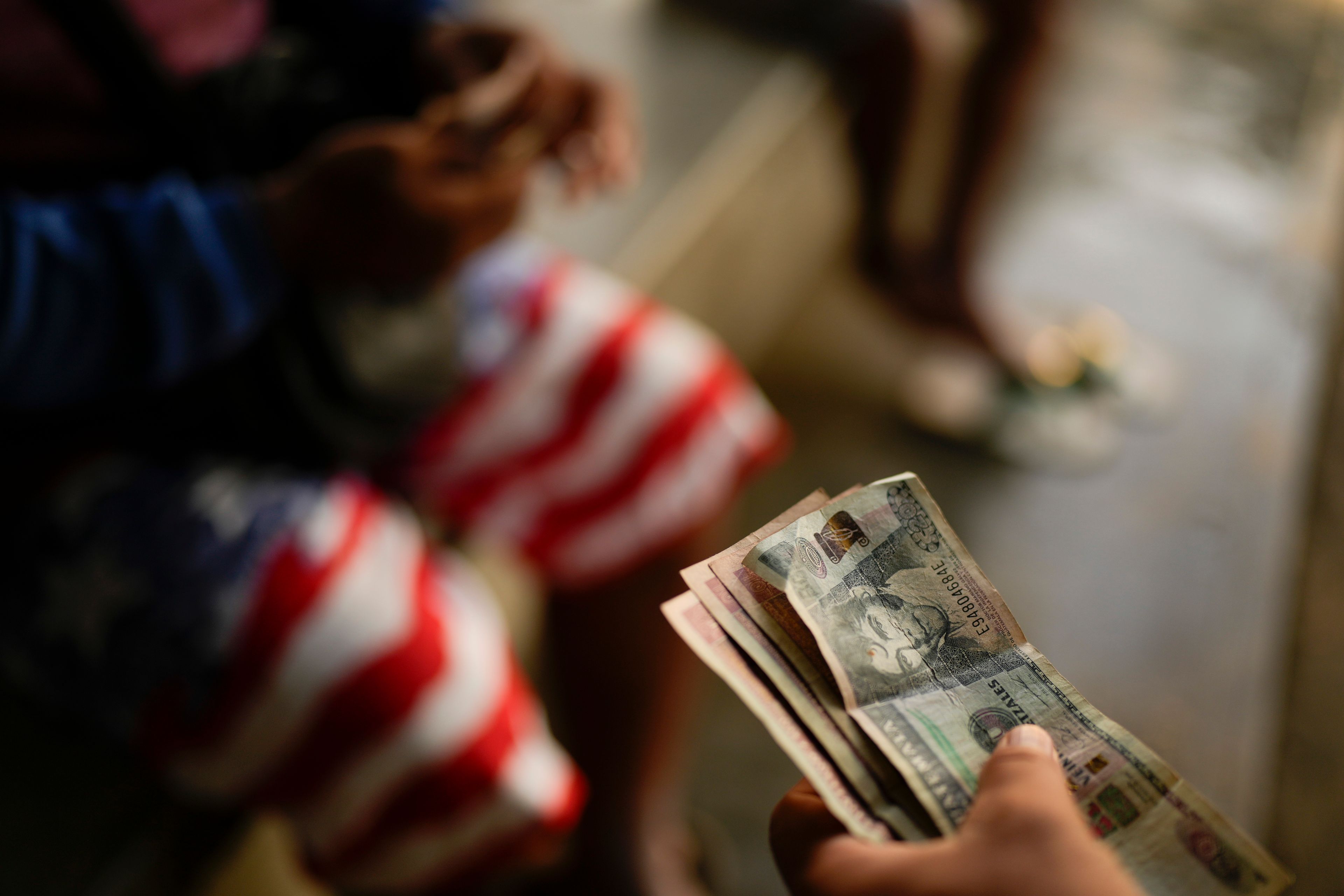 Honduran migrant Gerzon Zavala exchanges Guatemalan quetzales for Mexican pesos after crossing the Suchiate River, which marks the border between Guatemala and Mexico, from Ciudad Hidalgo, Mexico, Monday, Oct. 28, 2024. (AP Photo/Matias Delacroix)