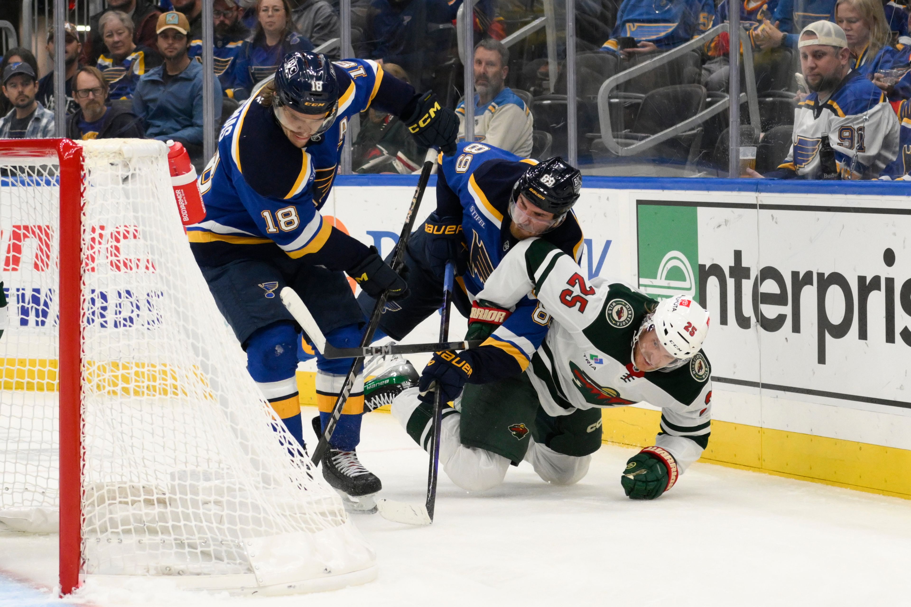 Minnesota Wild defenseman Jonas Brodin, right, is checked by St. Louis Blues left wing Pavel Buchnevich as center Robert Thomas, left, controls the puck during the second period of an NHL hockey game Tuesday, Nov. 19, 2024, in St. Louis.