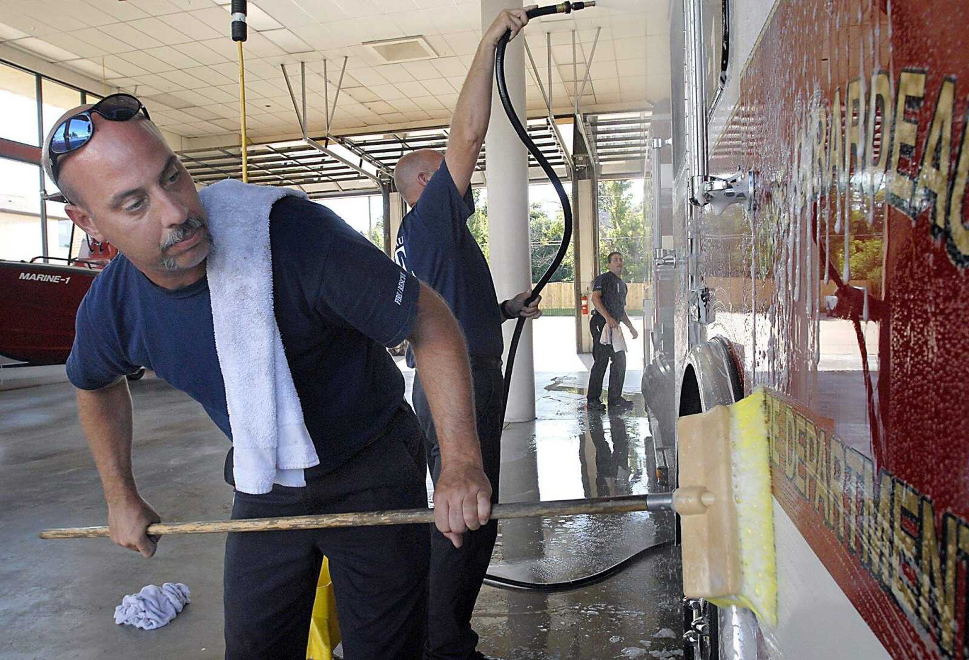 KIT DOYLE ~ kdoyle@semissourian.com
Gale Phillips, left, scrubbed, Mark Starnes rinsed, and JoJo Stuart dried as the Cape Girardeau firefighters washed an engine Tuesday afternoon, June 17, 2008, at Station 1 on South Sprigg St. Station 3 is on North Sprigg St.