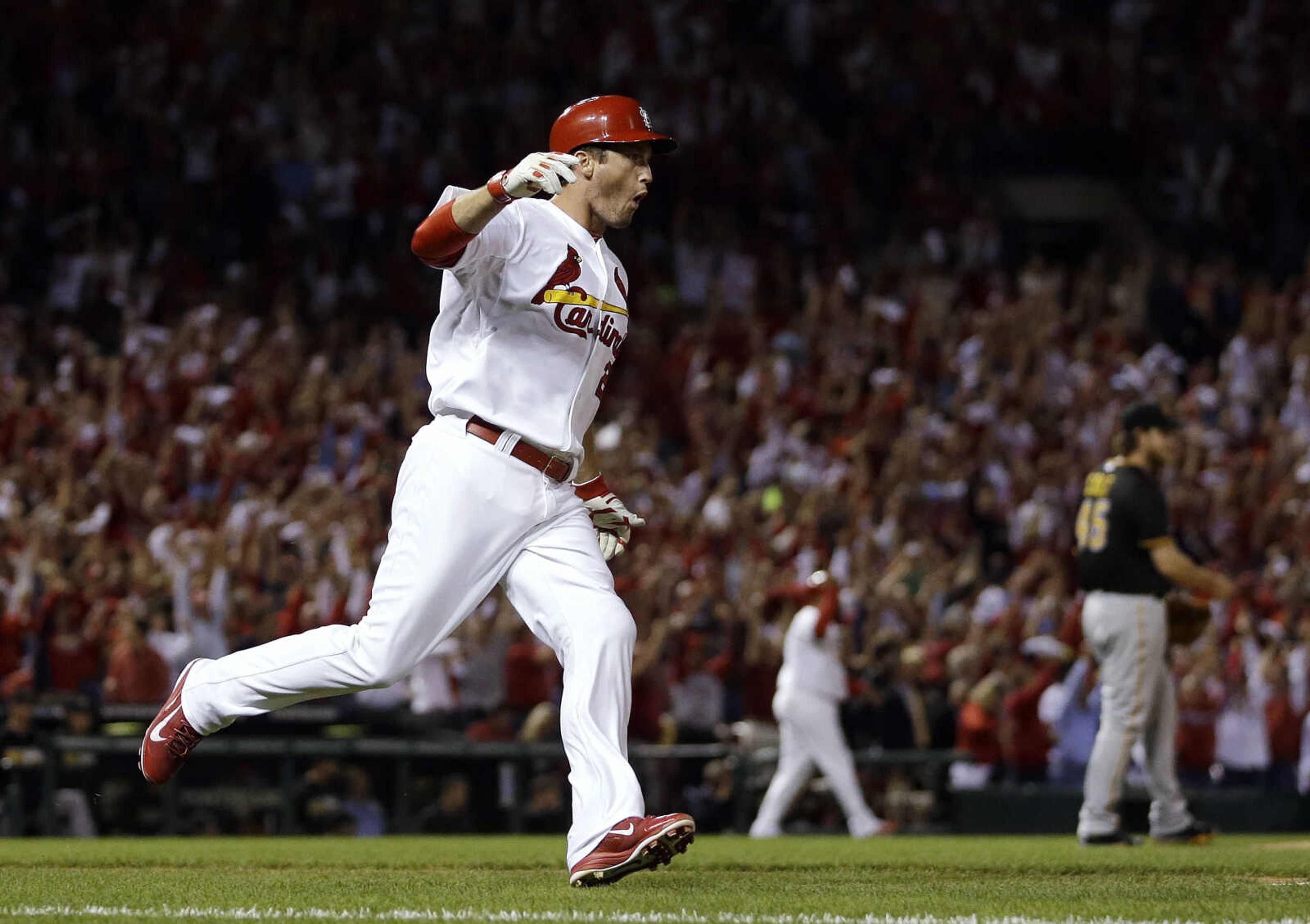 St. Louis Cardinals' David Freese runs to first base after hitting a two-run home run against Pittsburgh Pirates starting pitcher Gerrit Cole, right, in the second inning of Game 5 of a National League baseball division series, Wednesday, Oct. 9, 2013, in St. Louis. (AP Photo/Jeff Roberson)