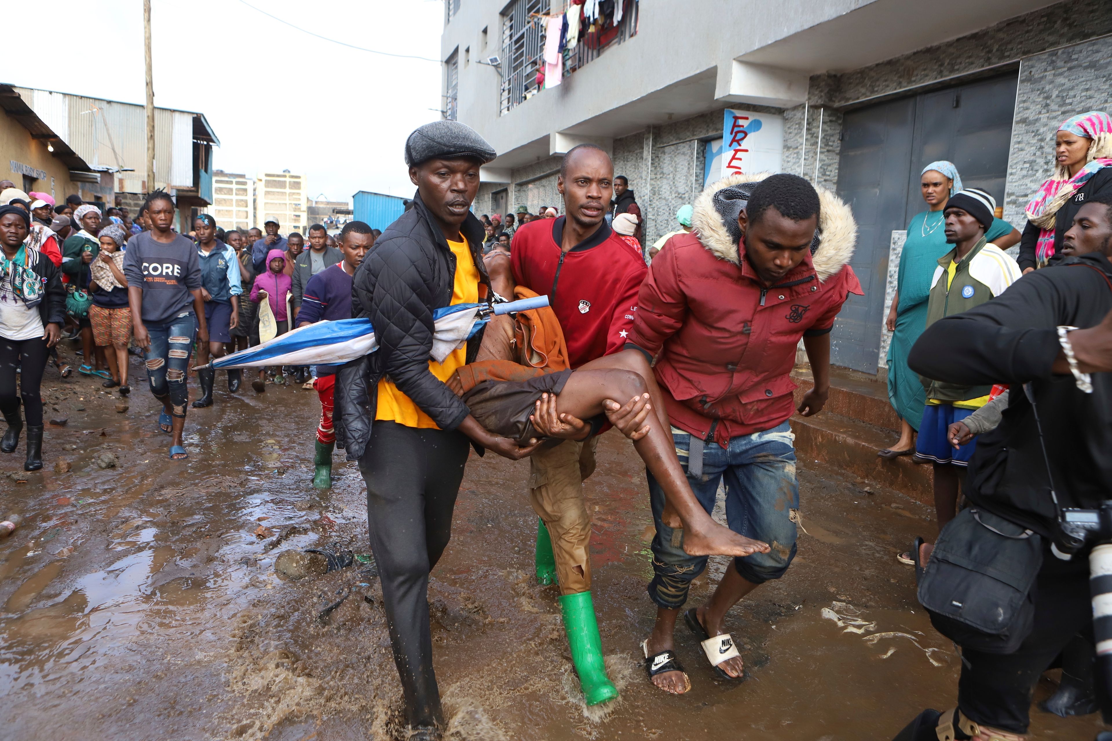 FILE - Residents rescue a woman who was caught during heavy rain in the Mathare slum of Nairobi, Kenya, Apr. 24, 2024. (AP Photo/Andrew Kasuku, File)