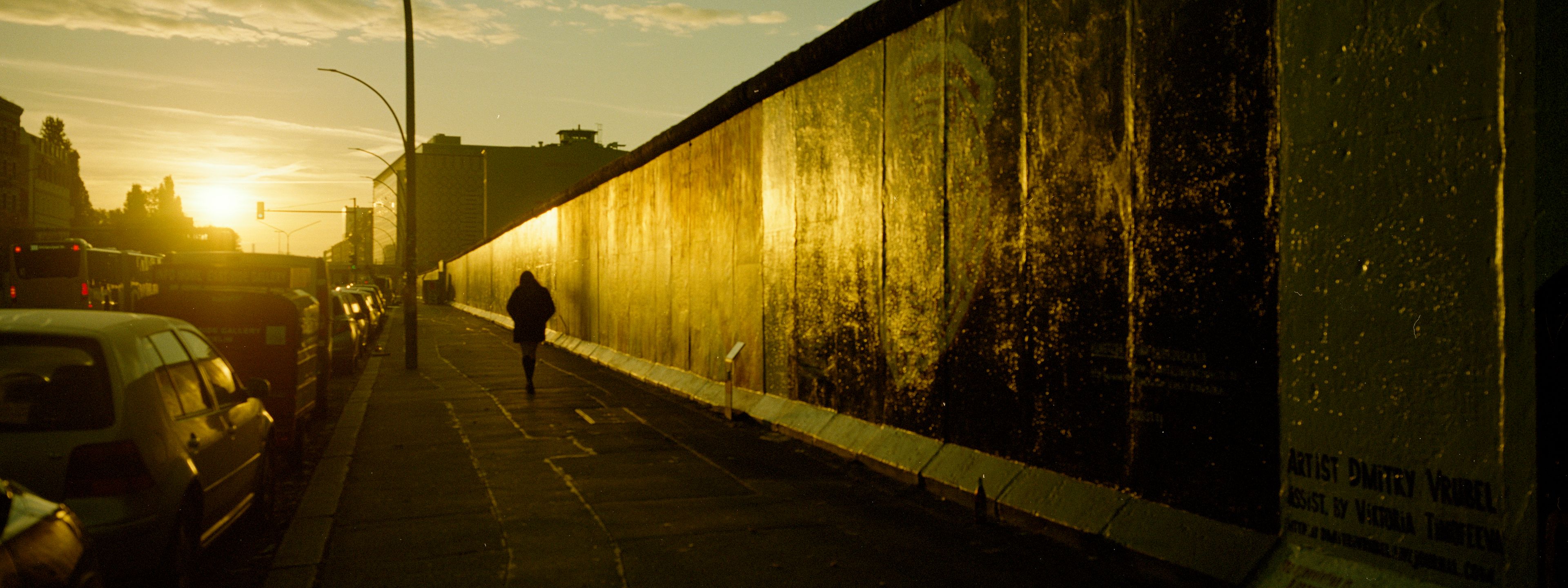 A person walks along the so-called East Side Gallery, a popular place for street art on remains of the Berlin Wall in Berlin, Germany, Tuesday, Oct. 22, 2024. (AP Photo/Markus Schreiber)