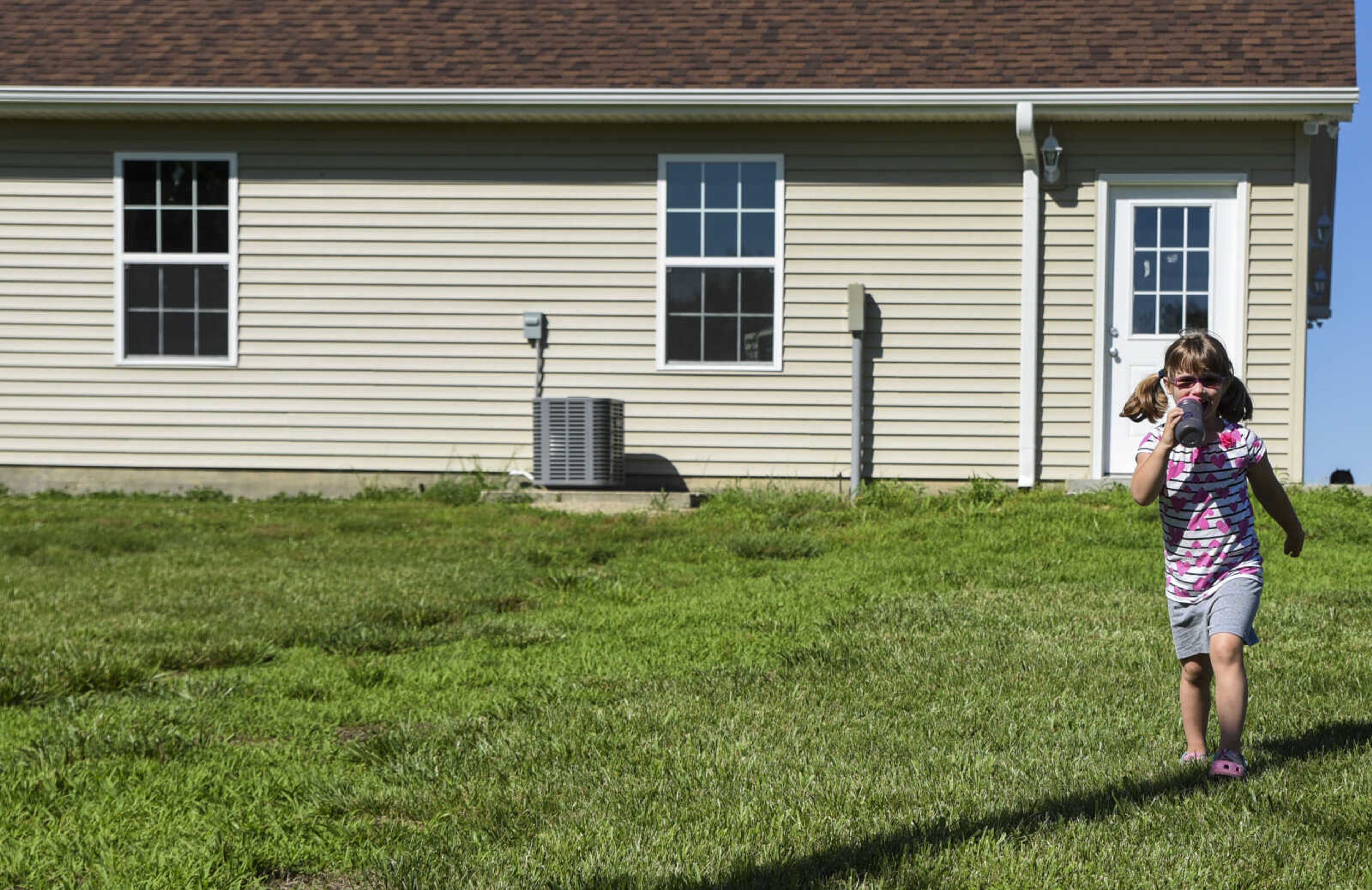 Lindyn Davenport, 6, walks through her backyard while drinking out of her water bottle Sunday, June 3, 2018 in Sedgewickville.