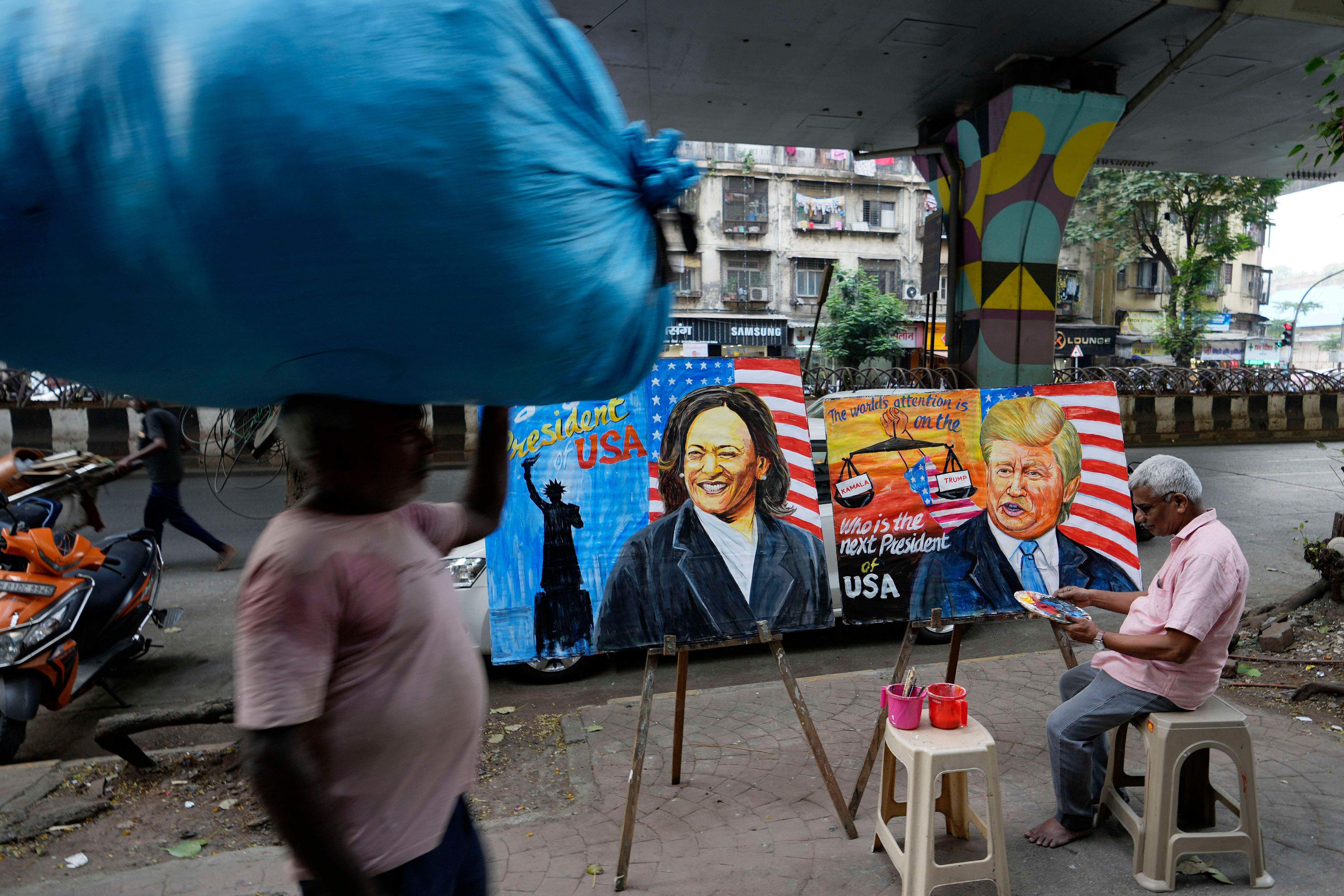 Art teacher Prithviraj Kambli paints posters of of US Vice President Kamala Harris and former President Donald Trump, outside his school in Mumbai, India, Tuesday, Nov. 5, 2024.(AP Photo/Rajanish Kakade)