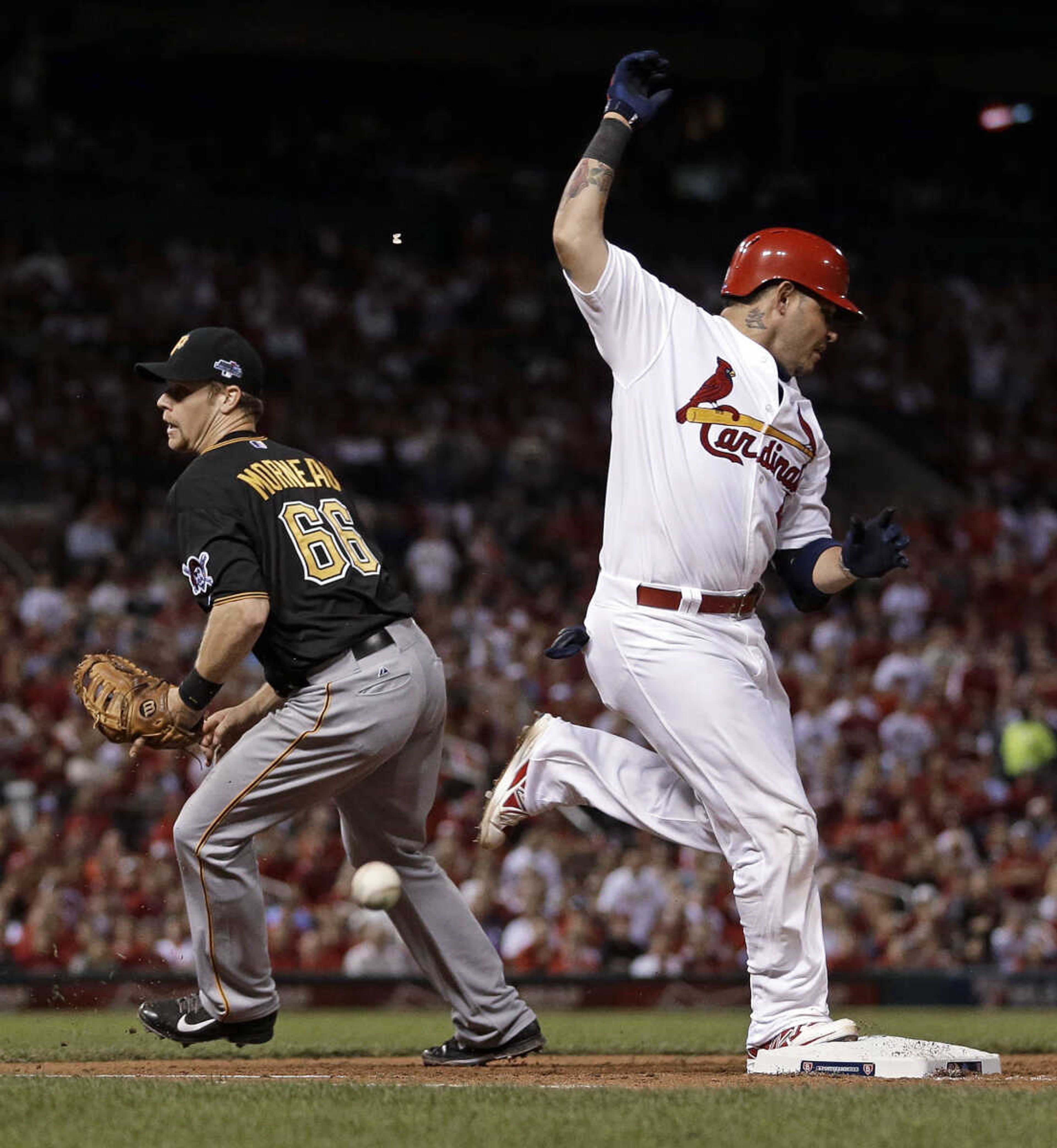 St. Louis Cardinals' Yadier Molina, right, is safe at first as the ball gets past Pittsburgh Pirates first baseman Justin Morneau in the fourth inning of Game 5 in a National League baseball division series on Wednesday, Oct. 9, 2013, in St. Louis. Molina was credited with a single on the play. (AP Photo/Jeff Roberson)