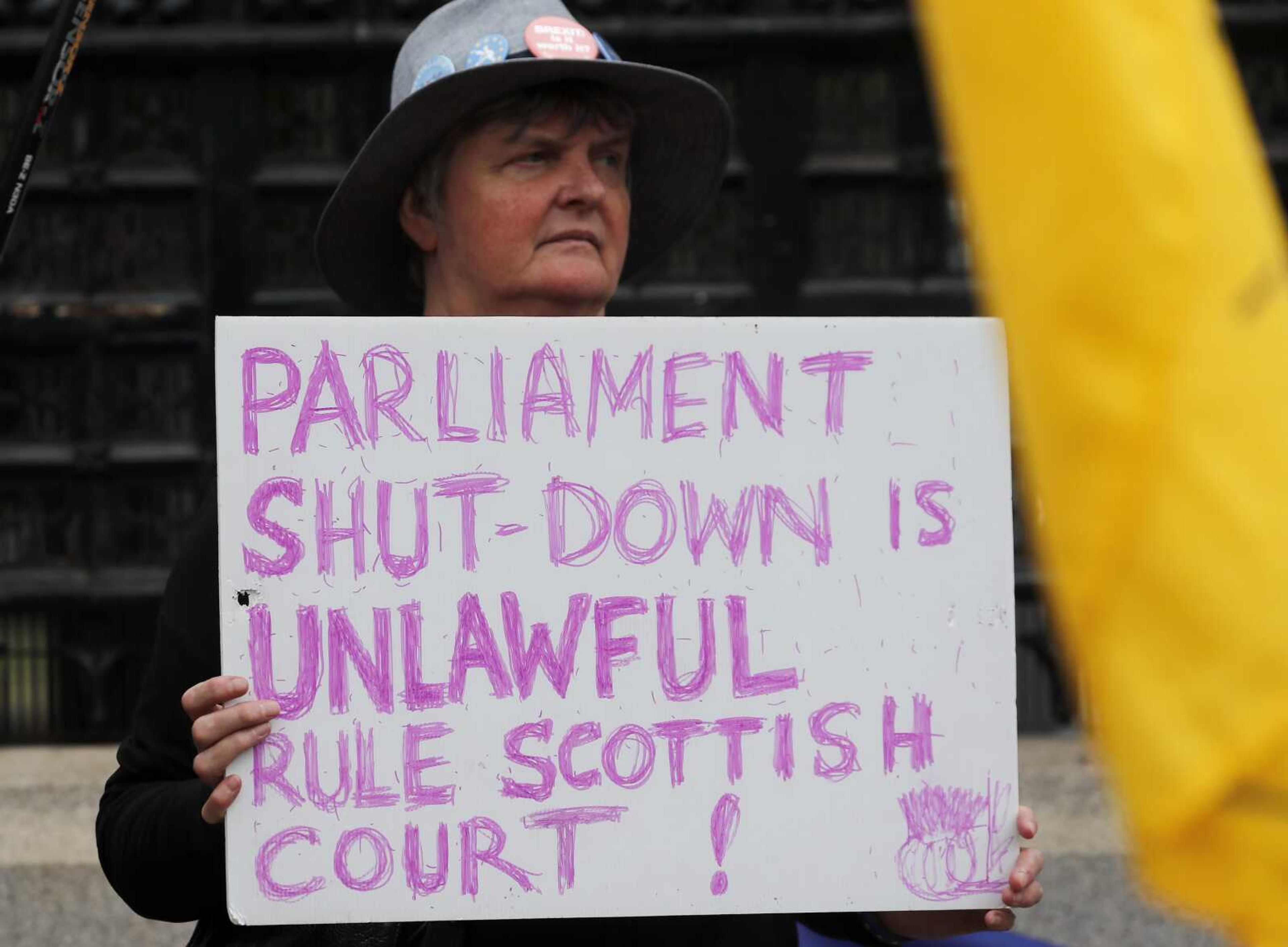 A pro-EU protester holds a poster Wednesday in front of the Houses of Parliament entrance in London.