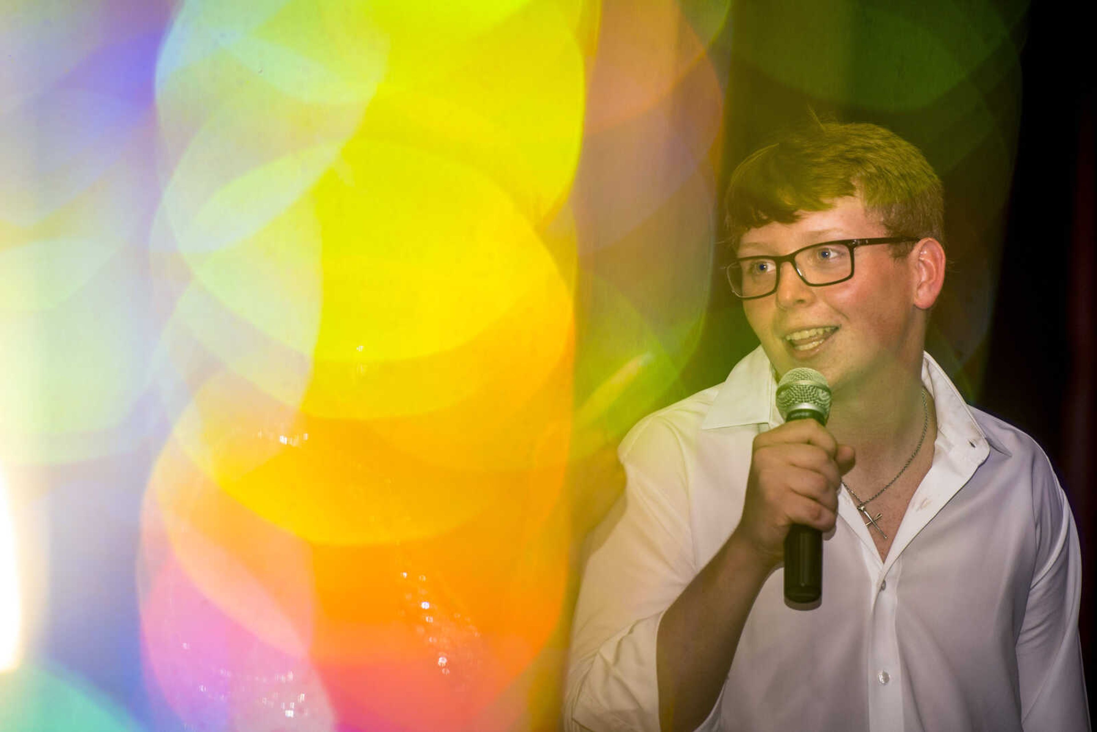 Grant Menz through reflected decorations singing along to George Strait's "Check Yes or No" during prom Saturday, April 6, 2019, at Kelly High School in Benton.