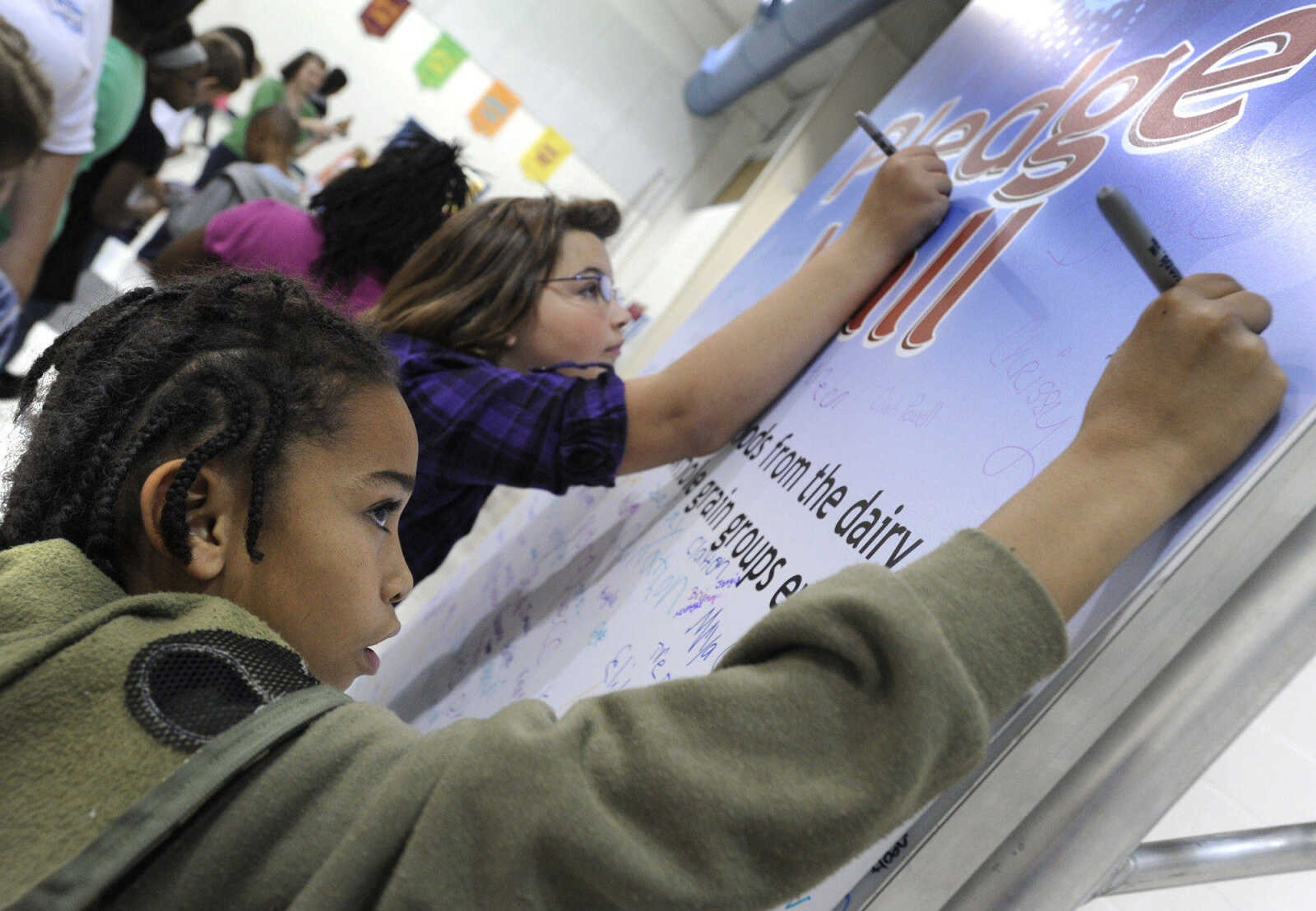 FRED LYNCH ~ flynch@semissourian.com
Lawrence Underwood, left, and Hailey Callender sign the pledge wall that they will eat more foods from the dairy, fruit, vegetable and whole grains groups every day on the Dairy Fully Fueled Tour, Tuesday, Nov. 9, 2010 at Franklin Elementary School.