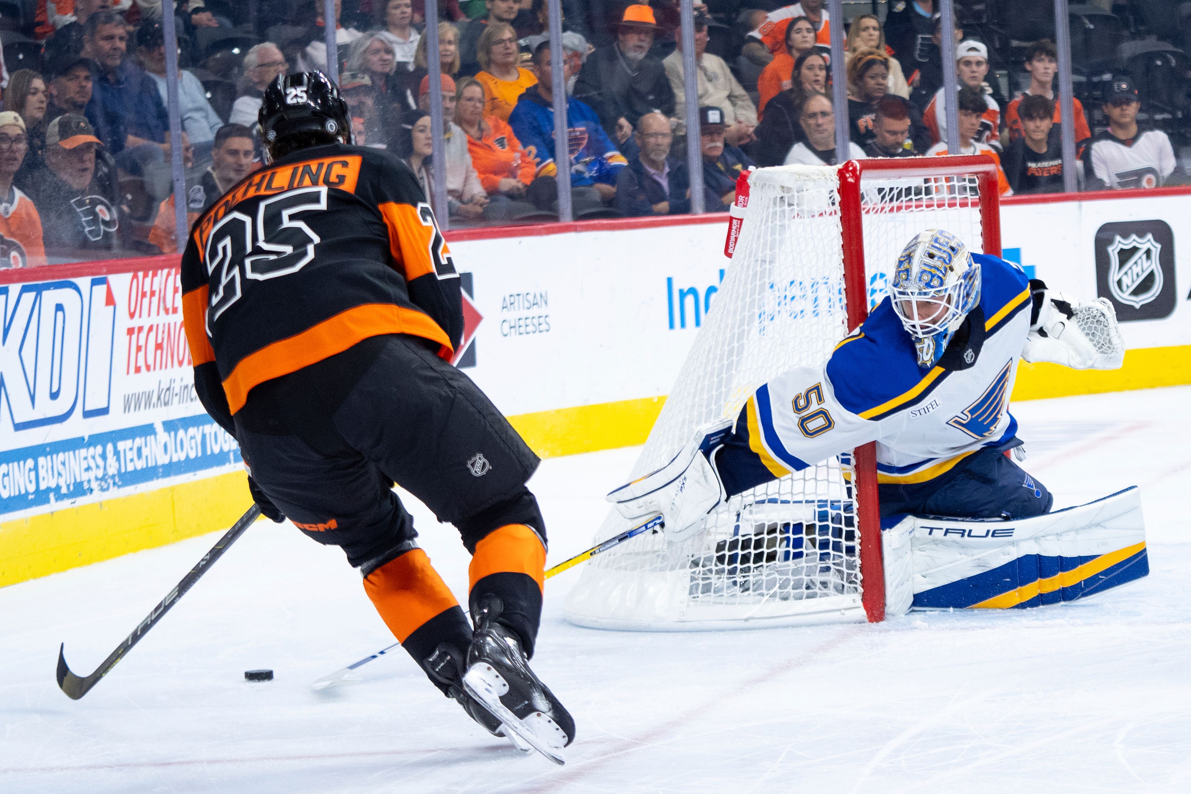 St Louis Blues' Jordan Binnington, right, knocks away the puck from Philadelphia Flyers' Ryan Poehling, left, during the second period of an NHL hockey game, Thursday, Oct. 31, 2024, in Philadelphia. (AP Photo/Chris Szagola)