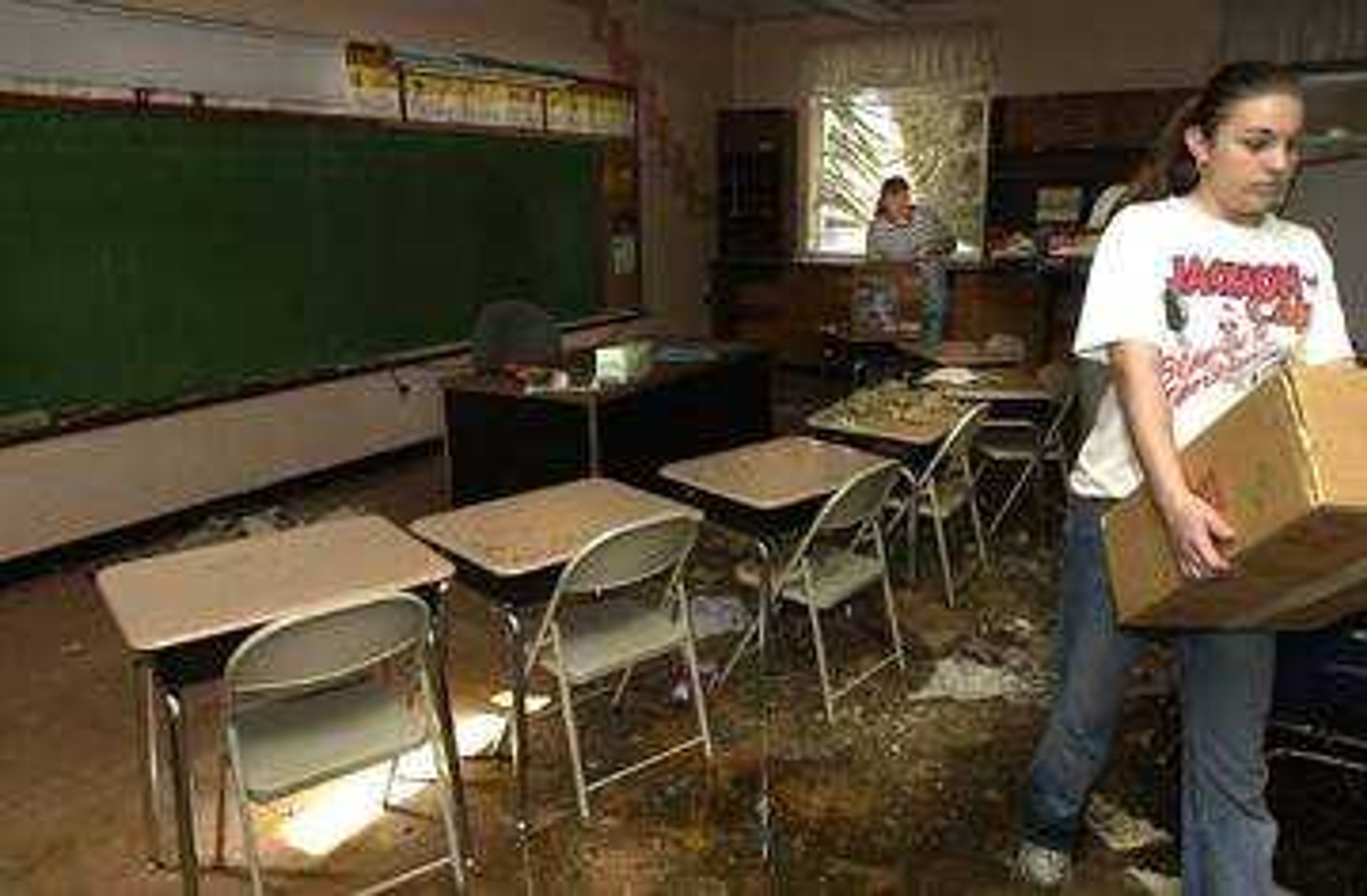 Sarah Wibber, right, helped Third Grade teacher Nan Beussink salvage anything they could in this Immaculate Conception School room.  The majority of the school was flooded from Tuesday's storm and teachers, students, and neighbors volunteered to help as much as possible.