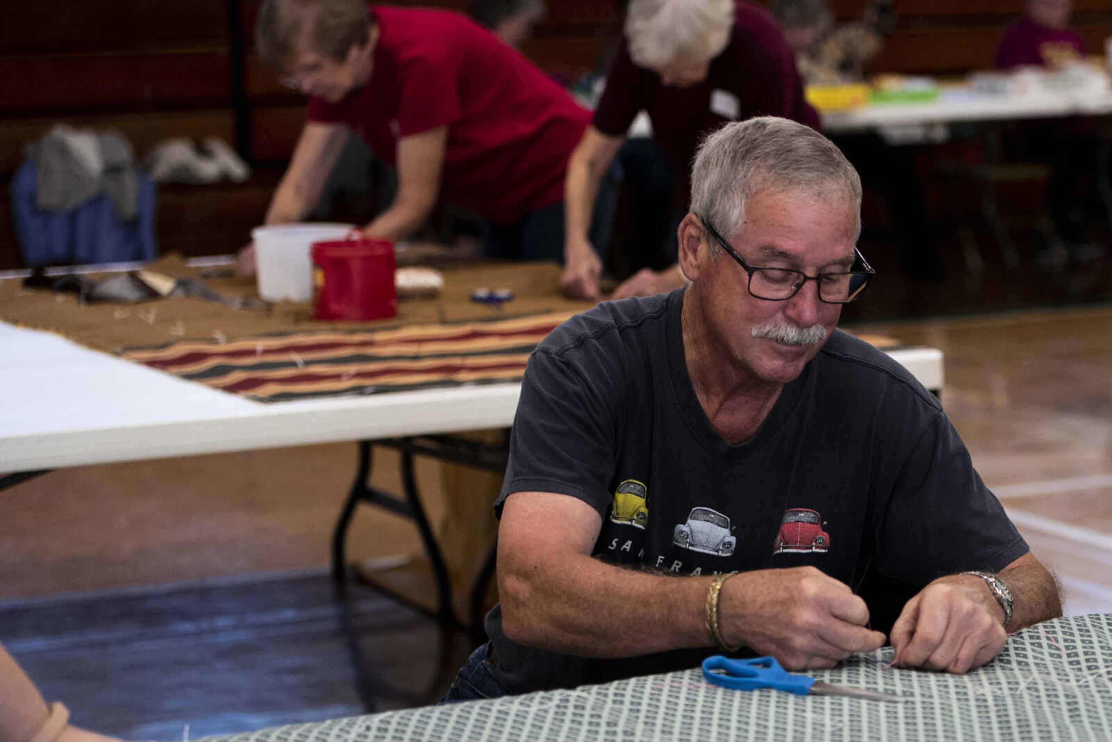 Allen Taylor tacks a quilted bed roll during the Ugly Quilt Weekend at St. Vincent de Paul Parish Sunday, Oct. 28, 2018, in Cape Girardeau.