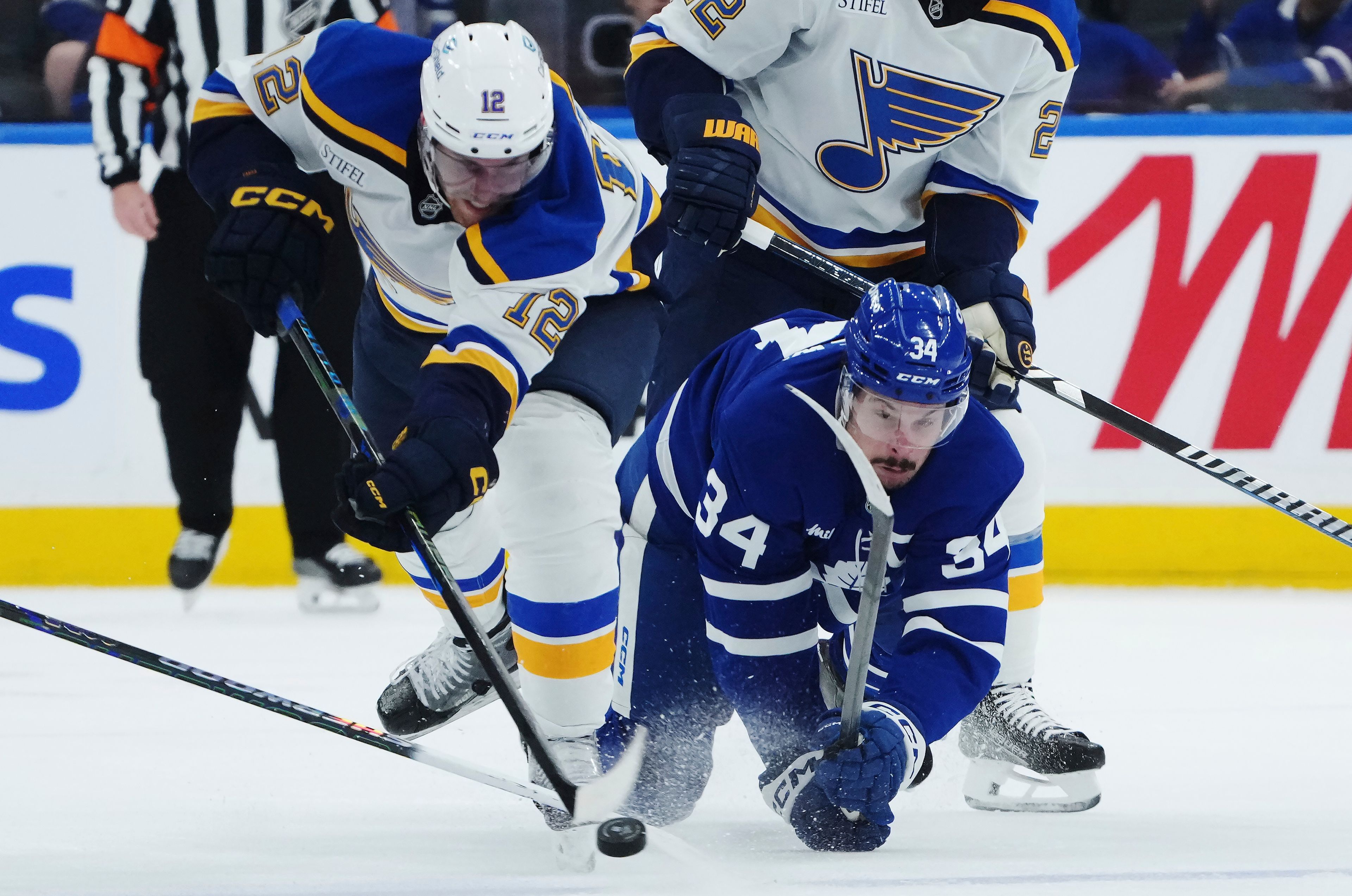 St. Louis Blues forward Radek Faksa (12) and Toronto Maple Leafs forward Auston Matthews (34) battle for the puck during third-period NHL hockey game action in Toronto, Thursday, Oct. 24, 2024. (Nathan Denette/The Canadian Press via AP)