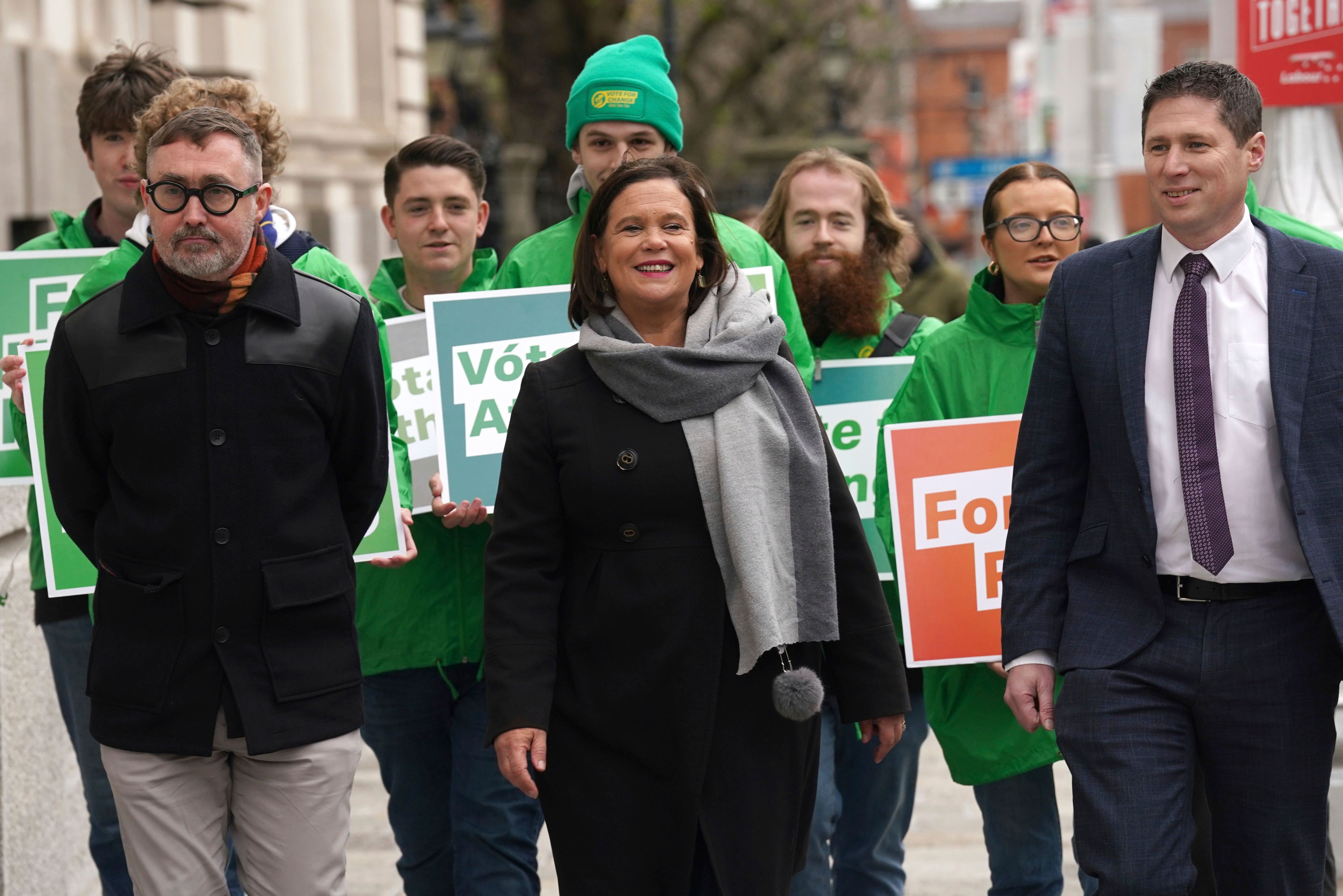 Sinn Fein leader Mary Lou McDonald, center, walks with candidates Eoin O Broin, left, Matt Carthy, right, and supporters arrive at Government Buildings, on the last day of campaigning on the eve of the General Election, in Dublin, Thursday, Nov. 28, 2024. (Brian Lawless/PA via AP)