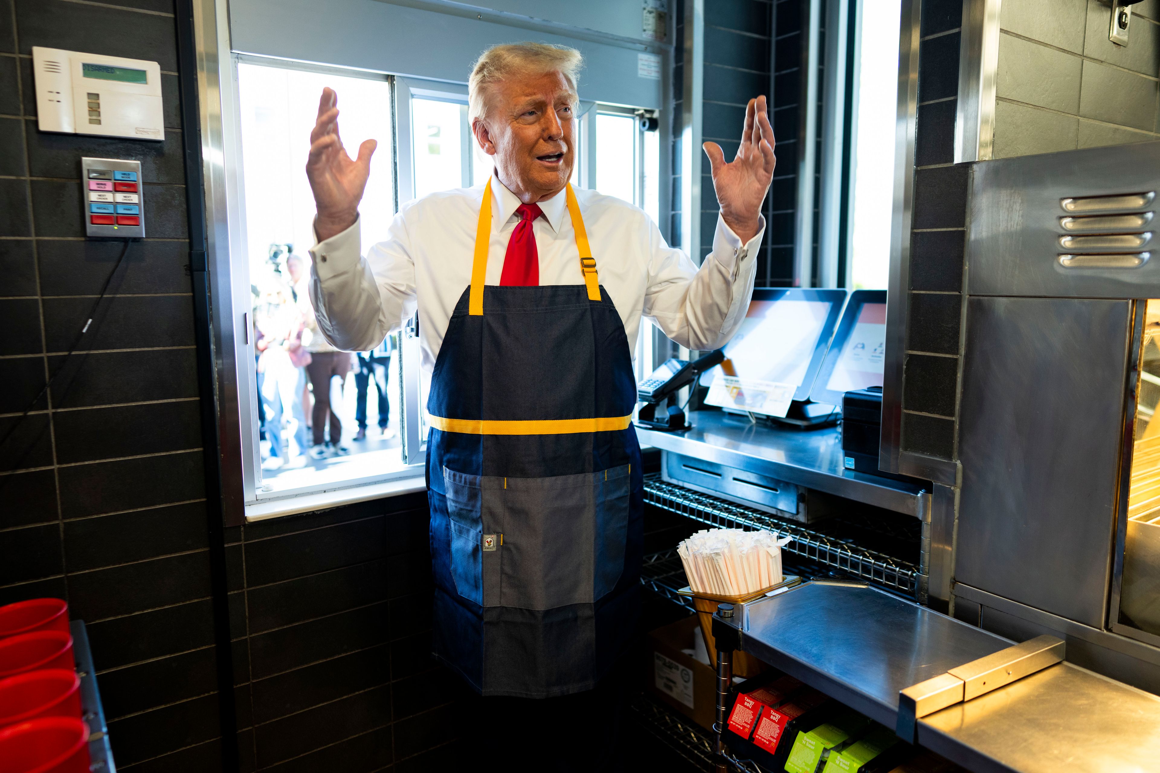 Republican presidential nominee former President Donald Trump stands at a drive-thru window during a campaign stop at a McDonald's in Feasterville-Trevose, Pa., Sunday, Oct. 20, 2024. (Doug Mills/The New York Times via AP, Pool)