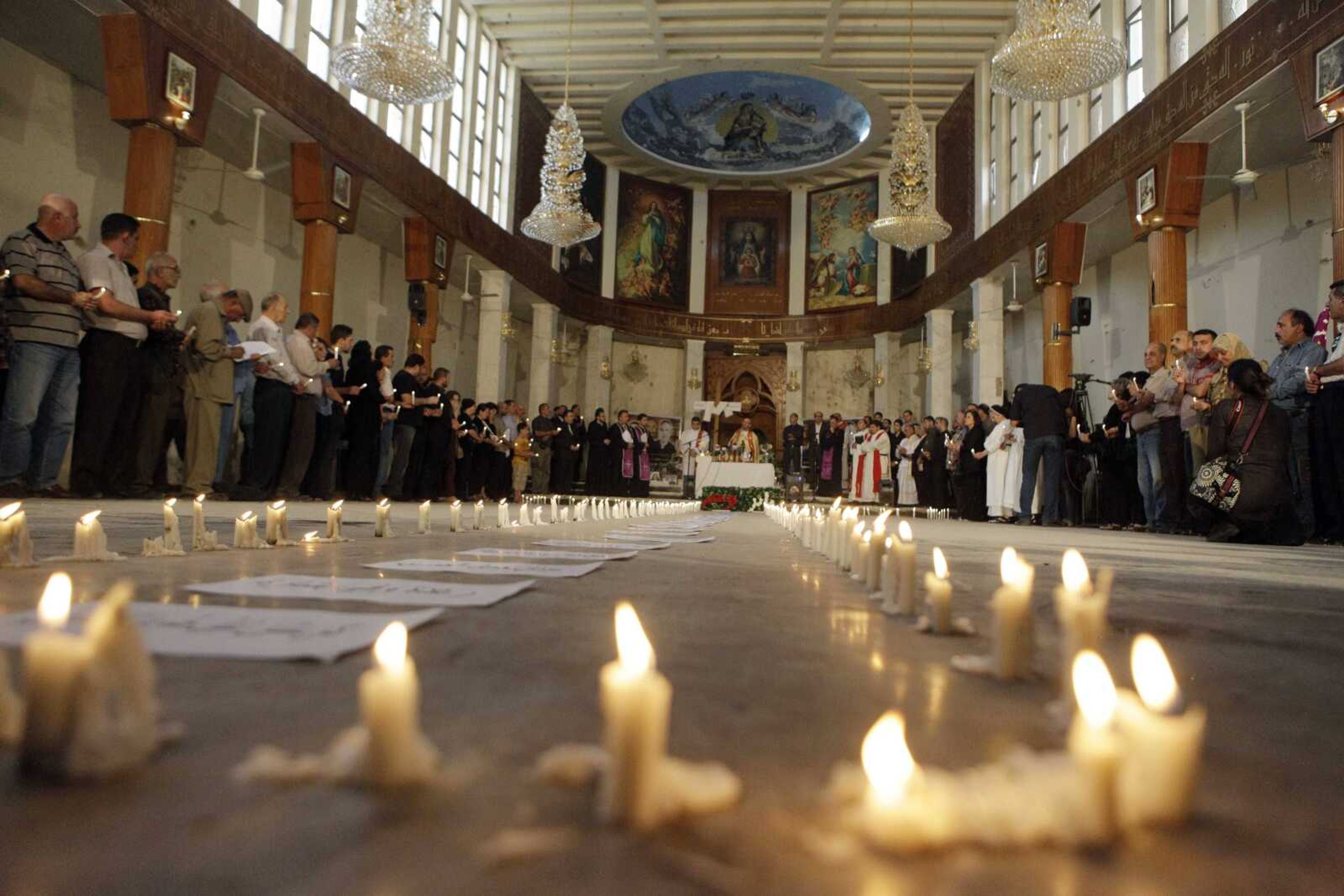 Followers attend a Mass on Sunday at Our Lady of Salvation church in Baghdad. An attack at the church a week earlier left dozens of people dead or injured. (Khalid Mohammed ~ Associated Press)