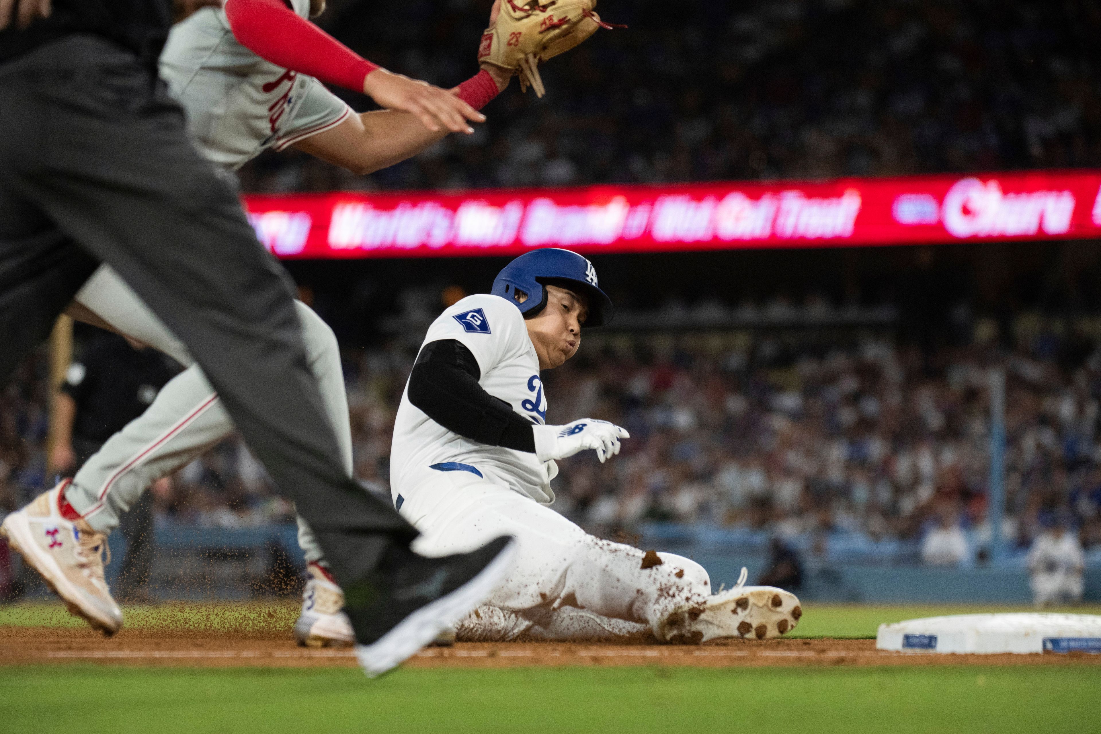 Los Angeles Dodgers' Shohei Ohtani, right, steals third base during the fifth inning of a baseball game against the Philadelphia Phillies in Los Angeles, Monday, Aug. 5, 2024. (AP Photo/Kyusung Gong)