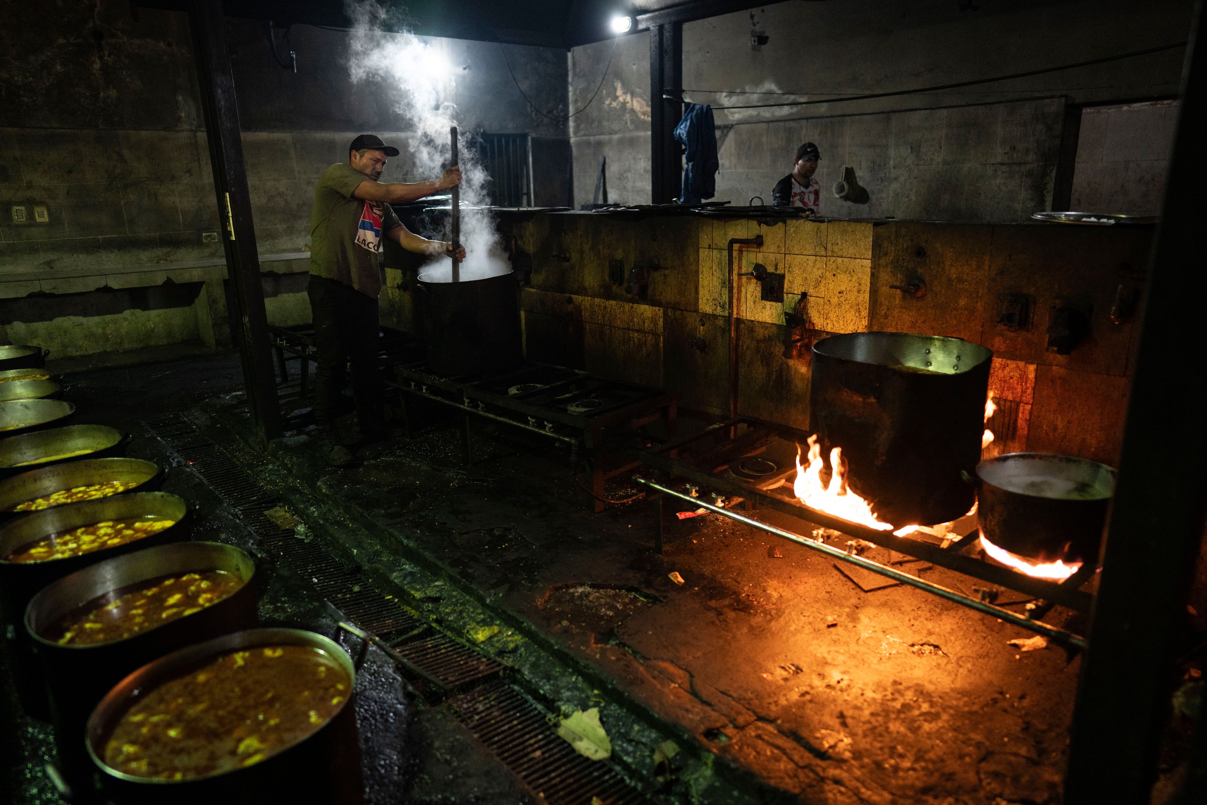 A prisoner cooks a vegetable, cheese and bean stew to serve at the Tacumbu prison in Asuncion, Paraguay, Sunday, July 8, 2024. (AP Photo/Rodrigo Abd)