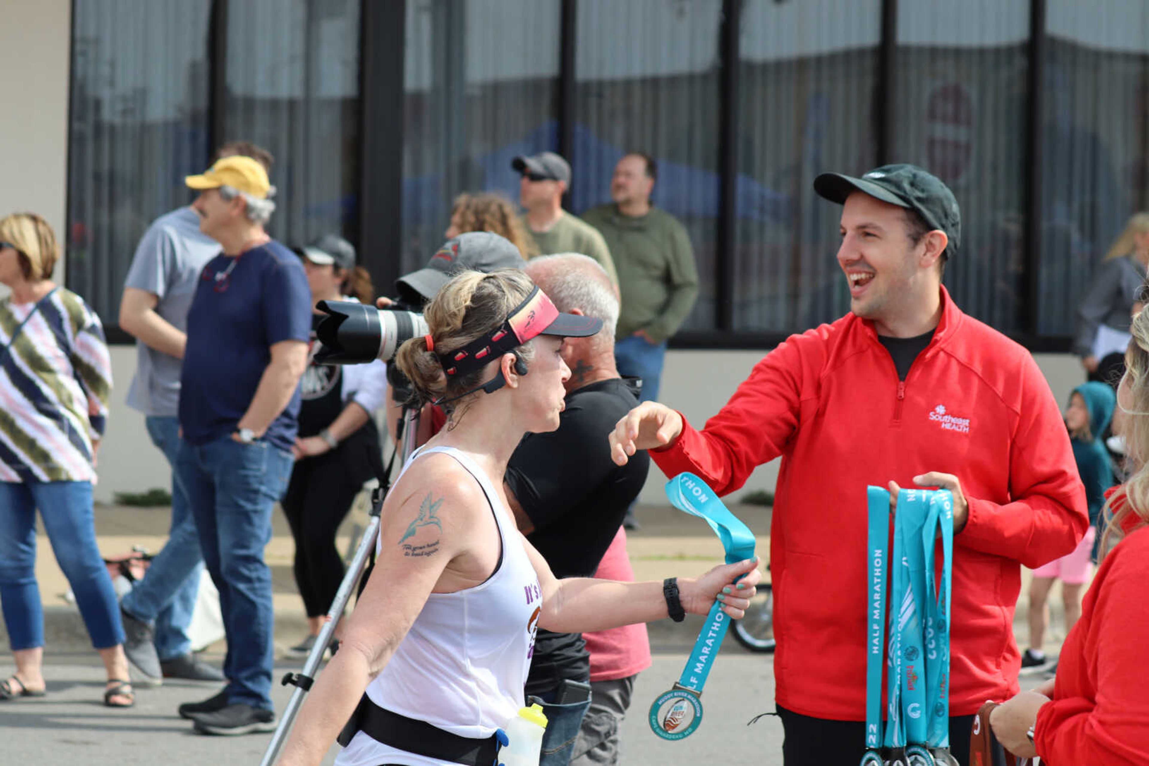 A runner getting handed their medal for their efforts in the marathon.