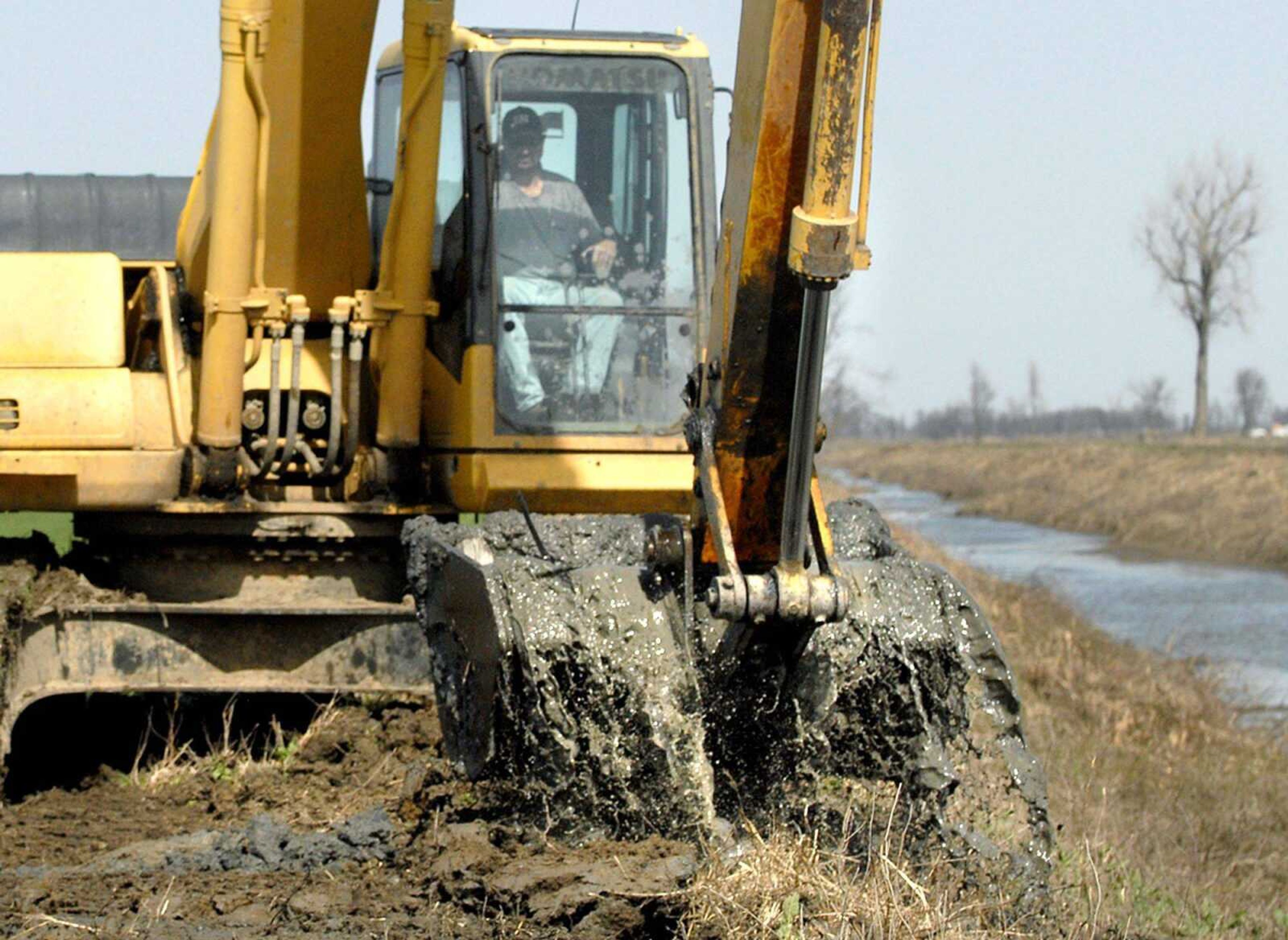 Chad Fodge with Schlosser Construction Co. scoops a load of silt Thursday morning from ditch No. 29 in Mississippi County. The silt is left over from last May's intentional breach of the Birds Point-New Madrid levee. (Laura Simon)