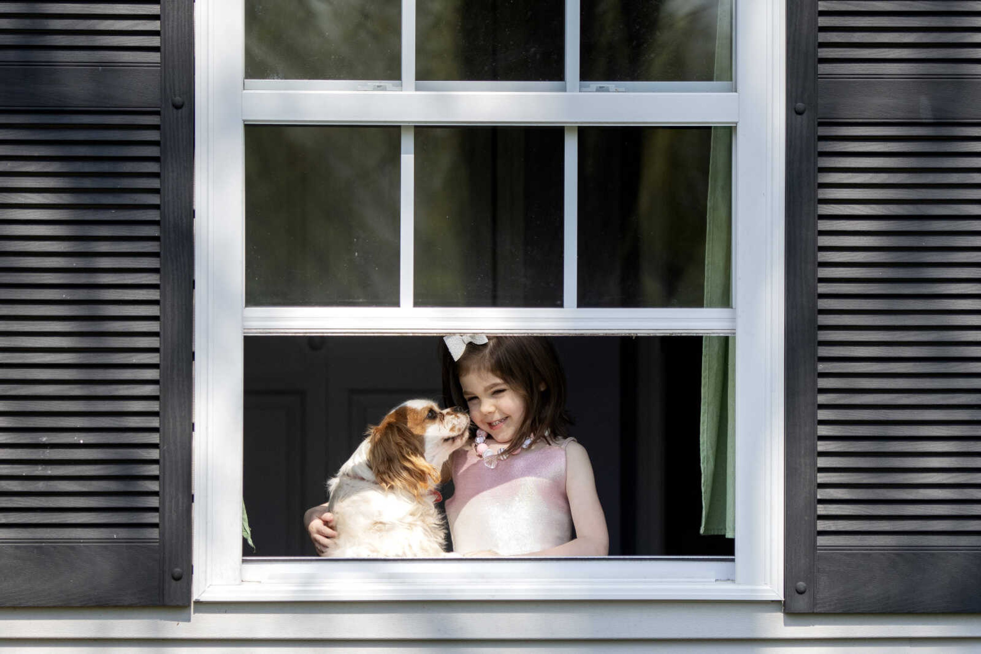 Annistyn "Anni" Bridges, 4, shares a moment with the dog, Nash, while taking a portrait Wednesday, April 8, 2020, at their Cape Girardeau home.