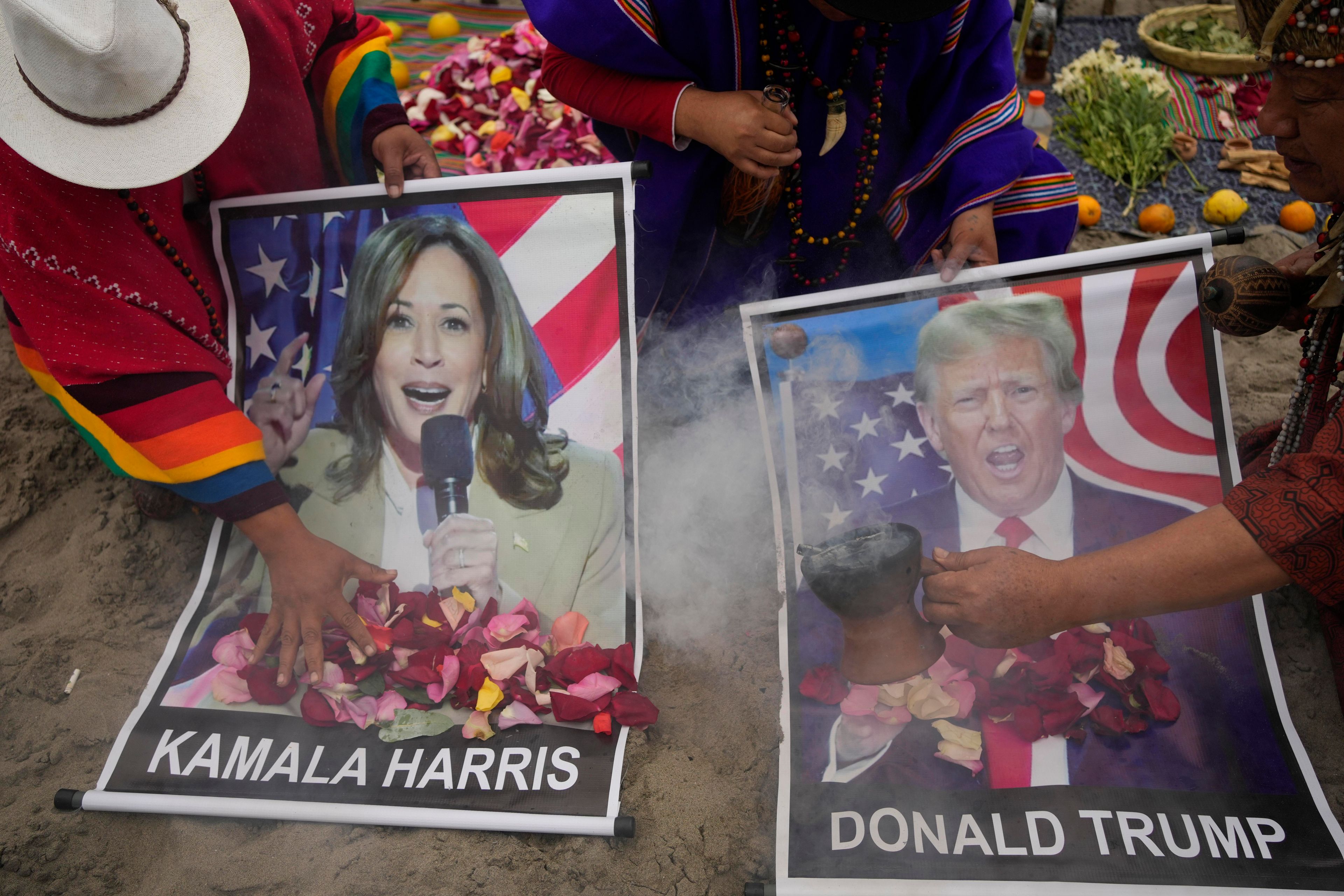 Shamans perform a good luck ritual holding posters of Democratic presidential nominee Vice President Kamala Harris and Republican presidential nominee former President Donald Trump, at the beach in Lima, Peru, Tuesday, Nov. 5, 2024. (AP Photo/Martin Mejia)