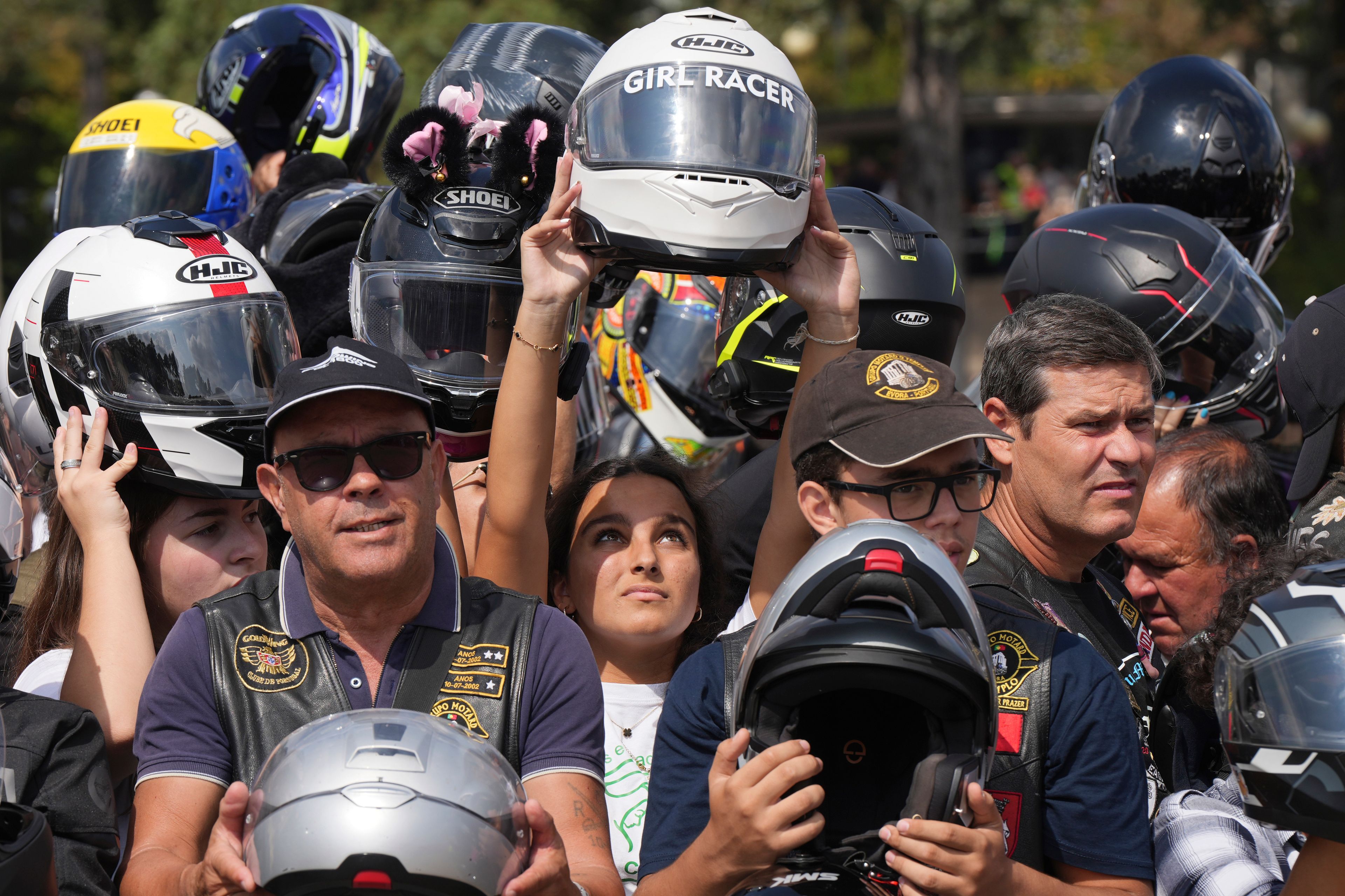 Faithful hold up their helmets to be blessed during the IX Pilgrimage of the Blessing of Helmets that draws tens of thousands at the Roman Catholic holy shrine of Fatima, in Fatima, Portugal, Sunday, Sept. 22, 2024. (AP Photo/Ana Brigida)