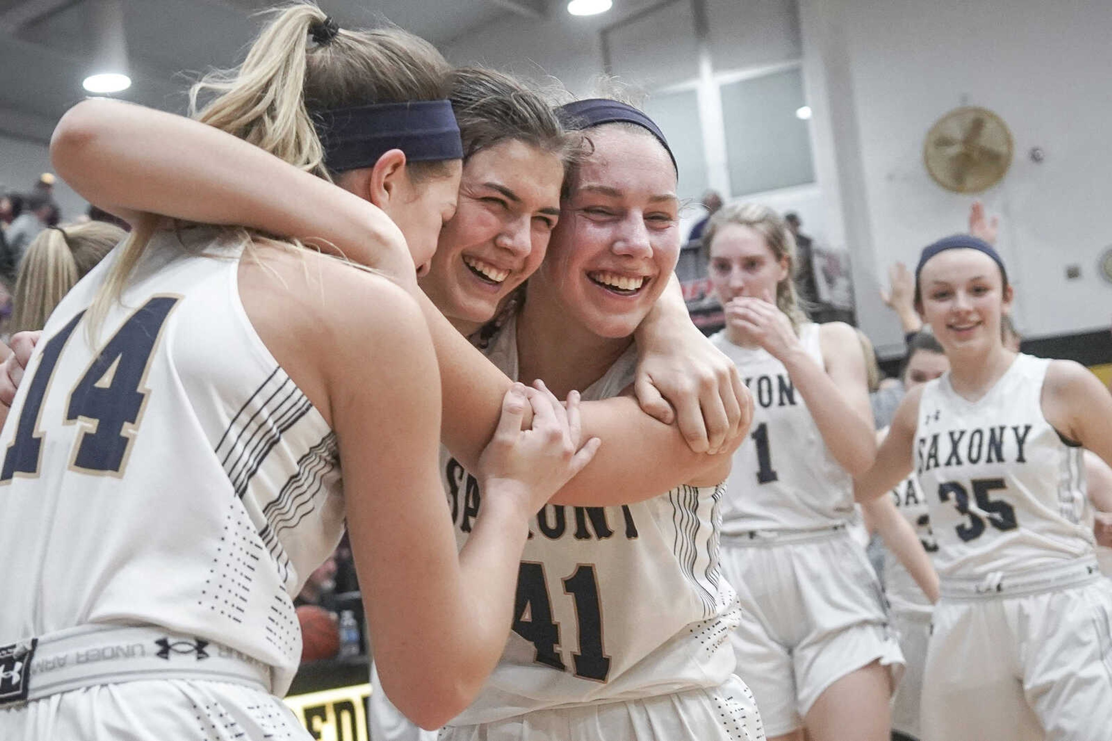 From left, Saxony Lutheran'sMaddox Murphy, Alice Hogendobler and Emma Brune hug after winning the Class 3, District 2 championship game Friday, Feb. 28, 2020, at Fredericktown High School  in Fredericktown.