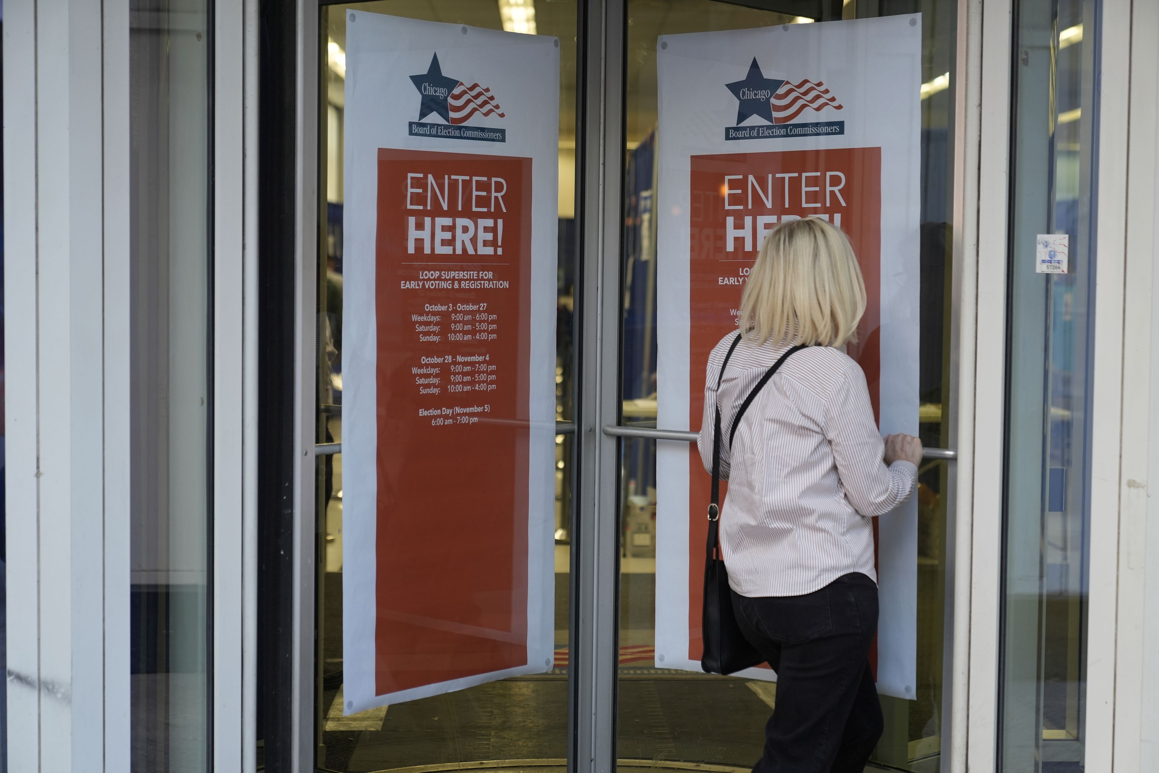 A person walks in to register on the first day of early voting for the 2024 Presidential General Election, Thursday, Oct. 3, 2024 in Chicago. (AP Photo/Charles Rex Arbogast)