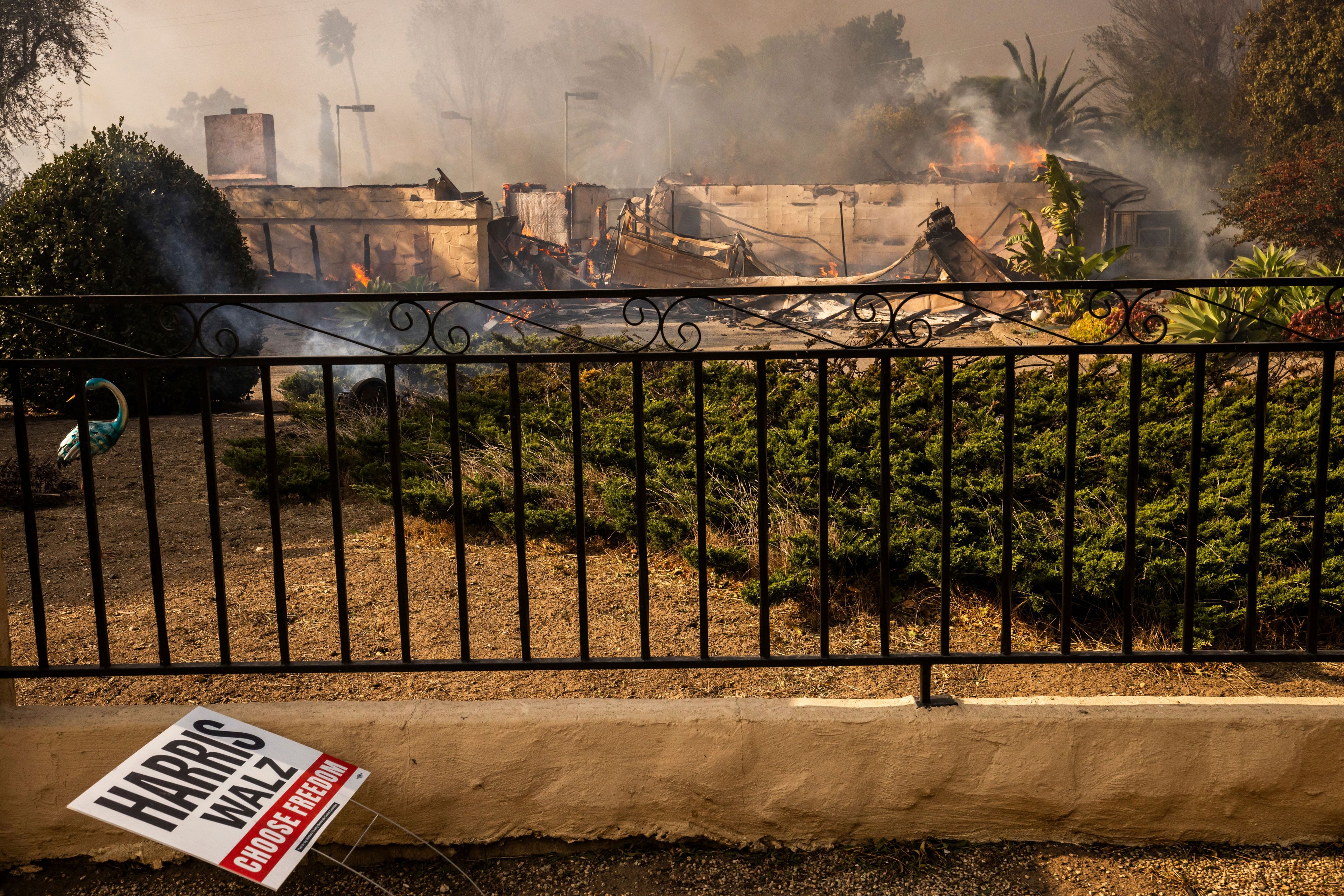 A political sign sits in front of a destroyed home in the Mountain fire, Wednesday, Nov. 6, 2024, near Camarillo, Calif. (AP Photo/Ethan Swope)