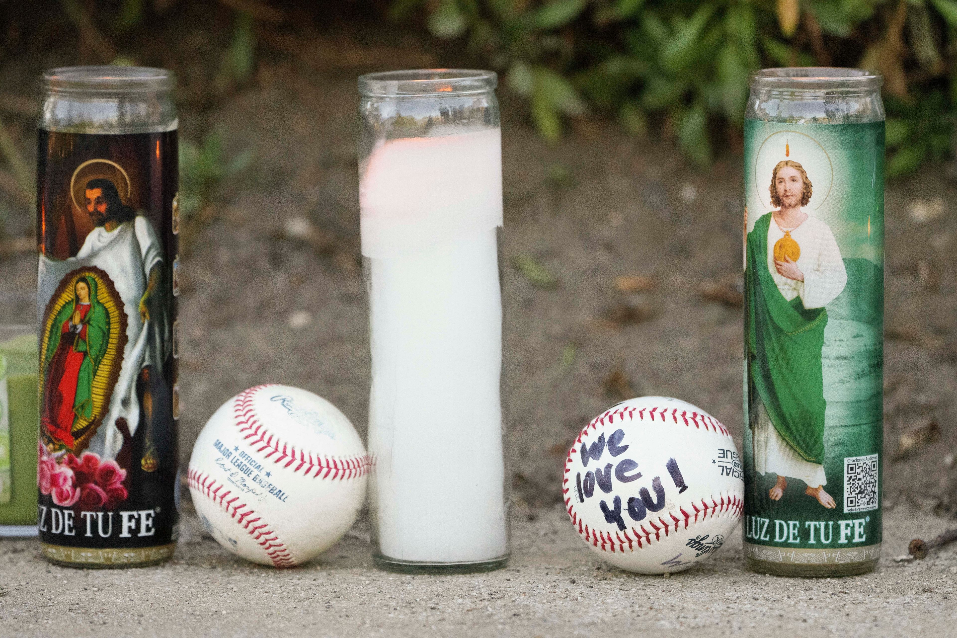 Candles and baseballs are placed outside Dodger Stadium after the death of former Dodgers pitcher Fernando Valenzuela, Wednesday, Oct. 23, 2024, in Los Angeles. (AP Photo/Damian Dovarganes)