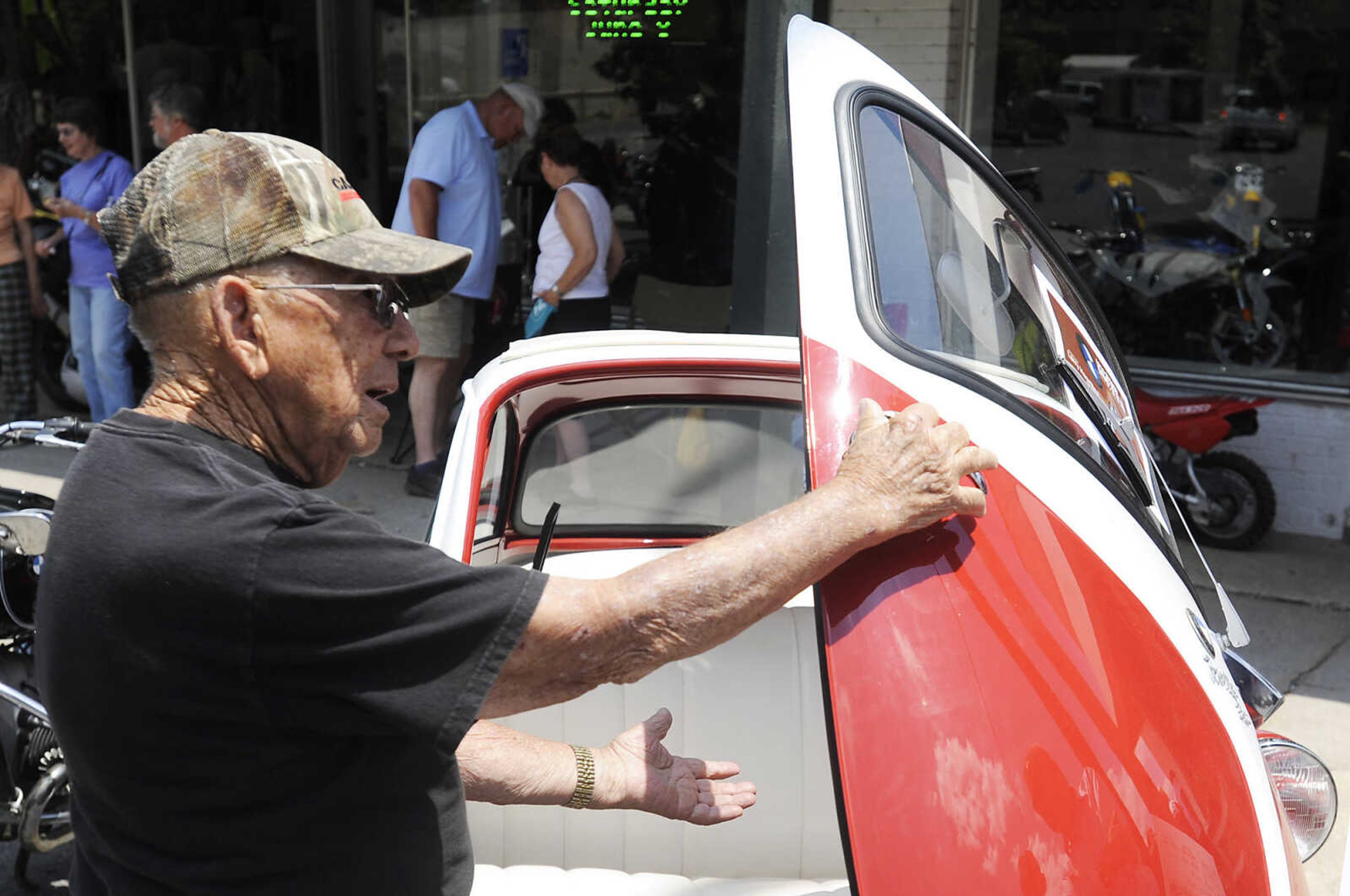 Curtis Jobe opens the door of Larry Haertling's 1958 BMW Isetta 300 at the Bikes on the Bikes on the River Vintage Motorcycle Show Saturday, June 8, at Grass Roots BMW, 28 S. Spanish St., in Cape Girardeau. Approximately 50 vintage motorcycles, and numerous newer bikes, were on display at the show which is in its second year and sponsored by Grass Root BMW. While there was no entry fee money was collected to be donated to St. Jude Children's Research Hospital. Organizers plan on holding the show again next year.