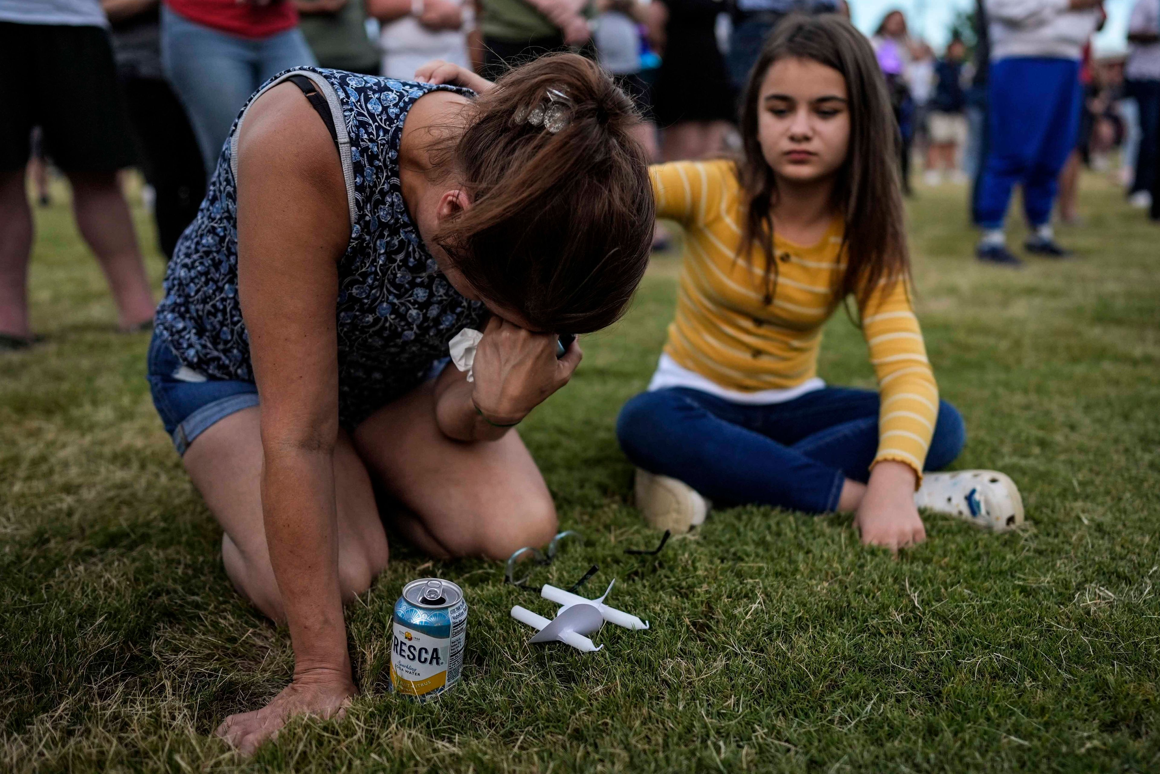 Brandy Rickaba and her daughter Emilie pray during a candlelight vigil for the slain students and teachers at Apalachee High School, Wednesday, Sept. 4, 2024, in Winder, Ga. (AP Photo/Mike Stewart)