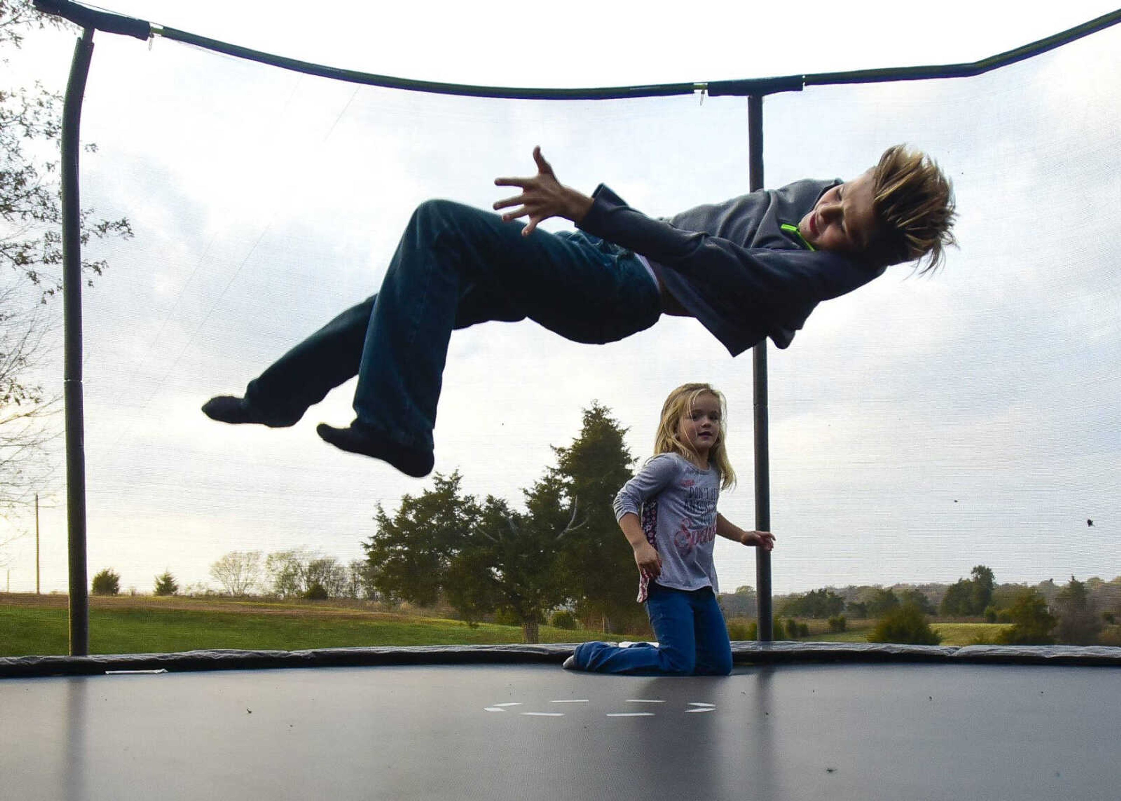 Connor Moore, 10, and his sister Raelyn Moore, 5, jump around on their trampoline Nov. 2 in Perryville, Missouri.