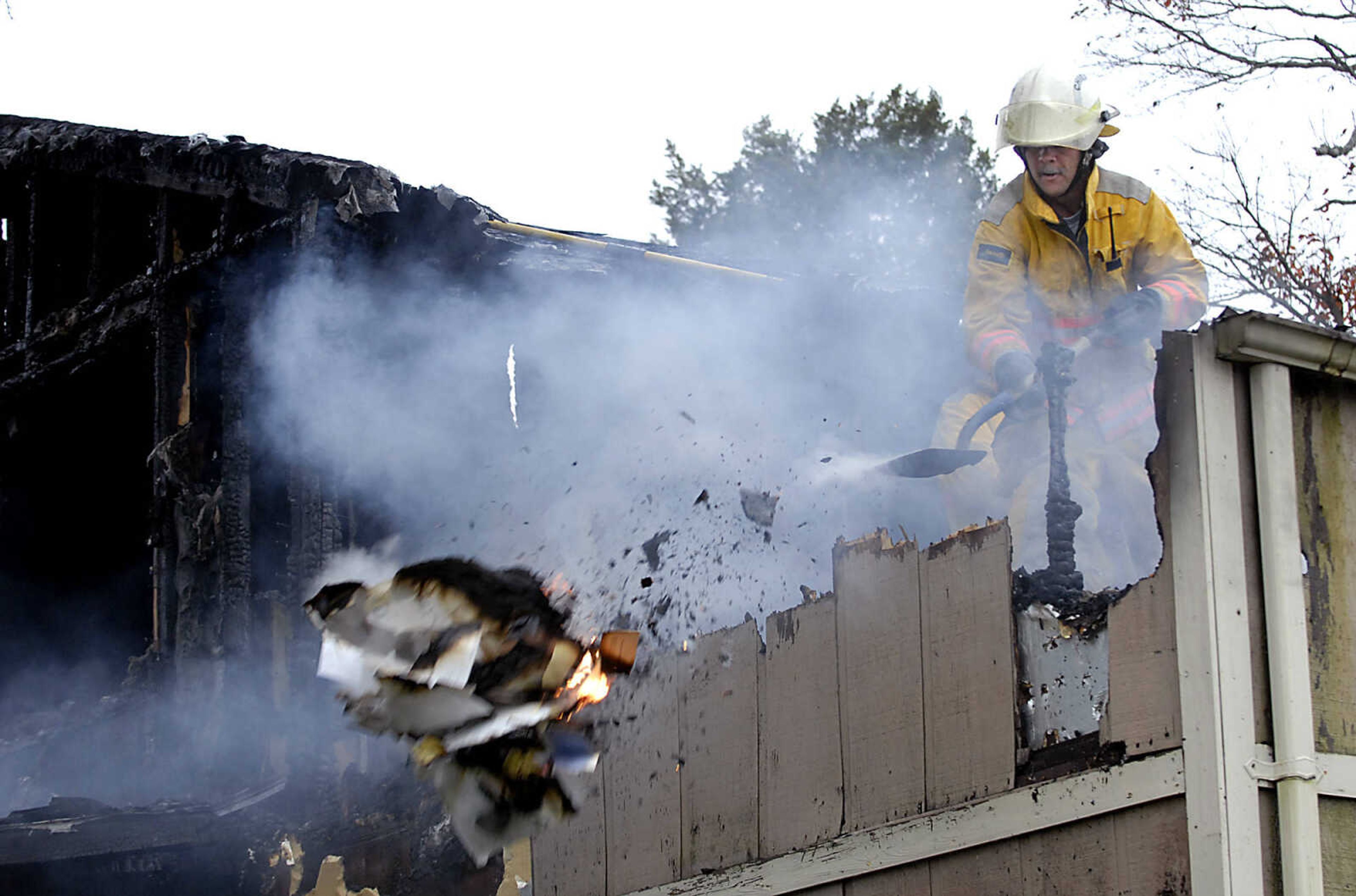 KIT DOYLE ~ kdoyle@semissourian.com
Fruitland Area Fire Department Chief Dean Riley shovels flaming piles of paper from the second floor of the Ladd home on Big Cone Lane Friday, October 16, 2009, north of Jackson.