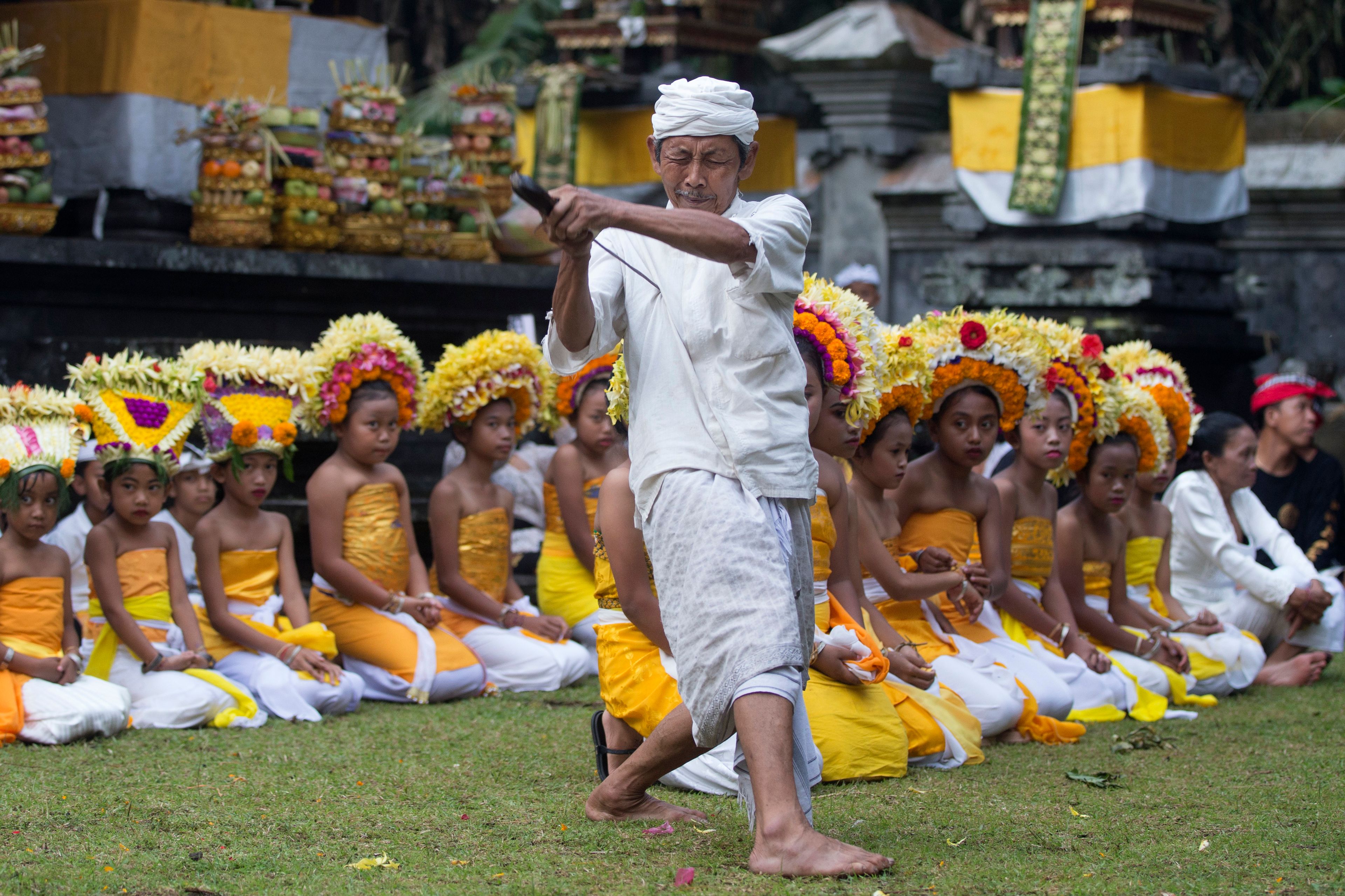 A Hindu priest in trance points keris, traditional dagger, on his chest during a Hindu ceremony at Geriana Kauh village, Karangasem, Bali, Indonesia, Thursday, Nov. 21, 2024. (AP Photo/Firdia Lisnawati)