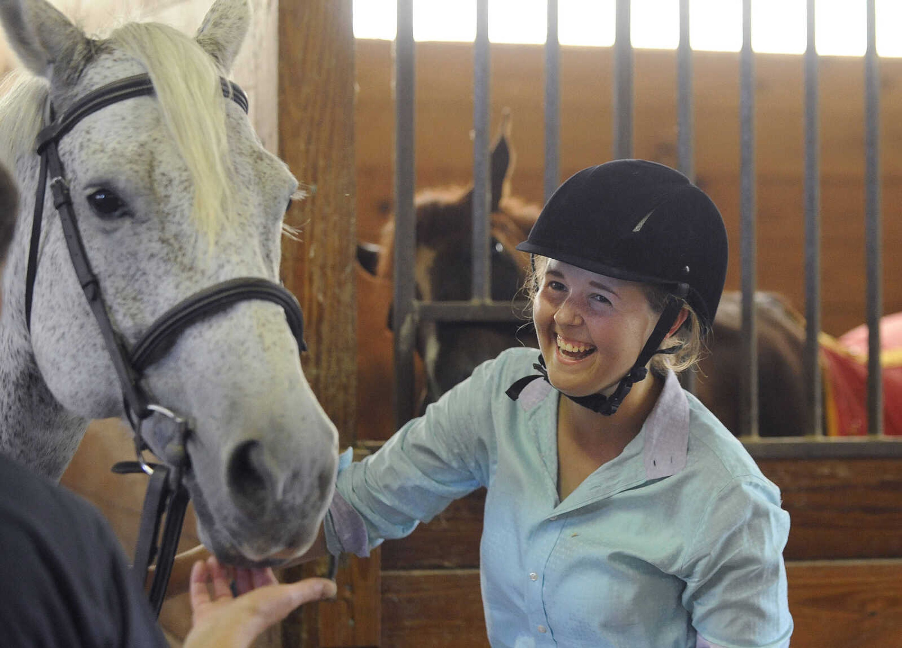 Haleigh Givens laughs in the stables before a mock meet at Ramley Equestrian Center in Cape Girardeau. (Glenn Landberg)