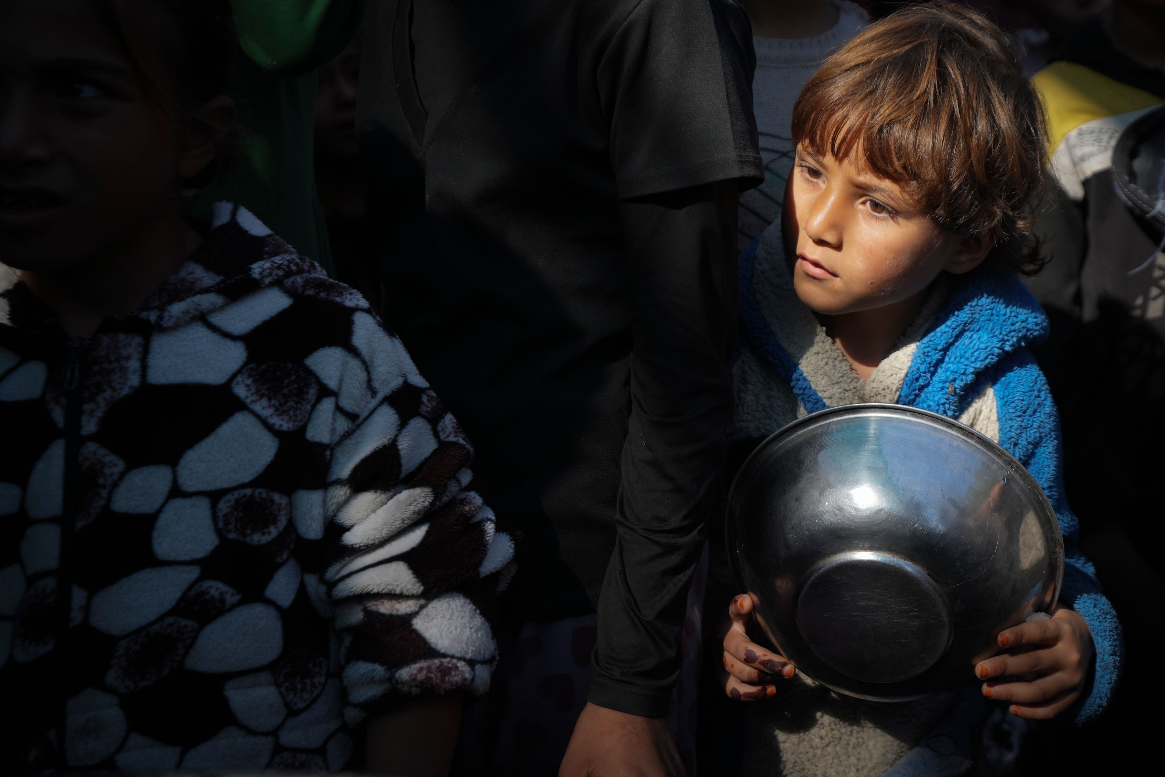 Palestinian children queue at a food distribution kitchen in Deir al-Balah, Gaza Strip, Friday Nov. 22, 2024. (AP Photo/Abdel Kareem Hana)