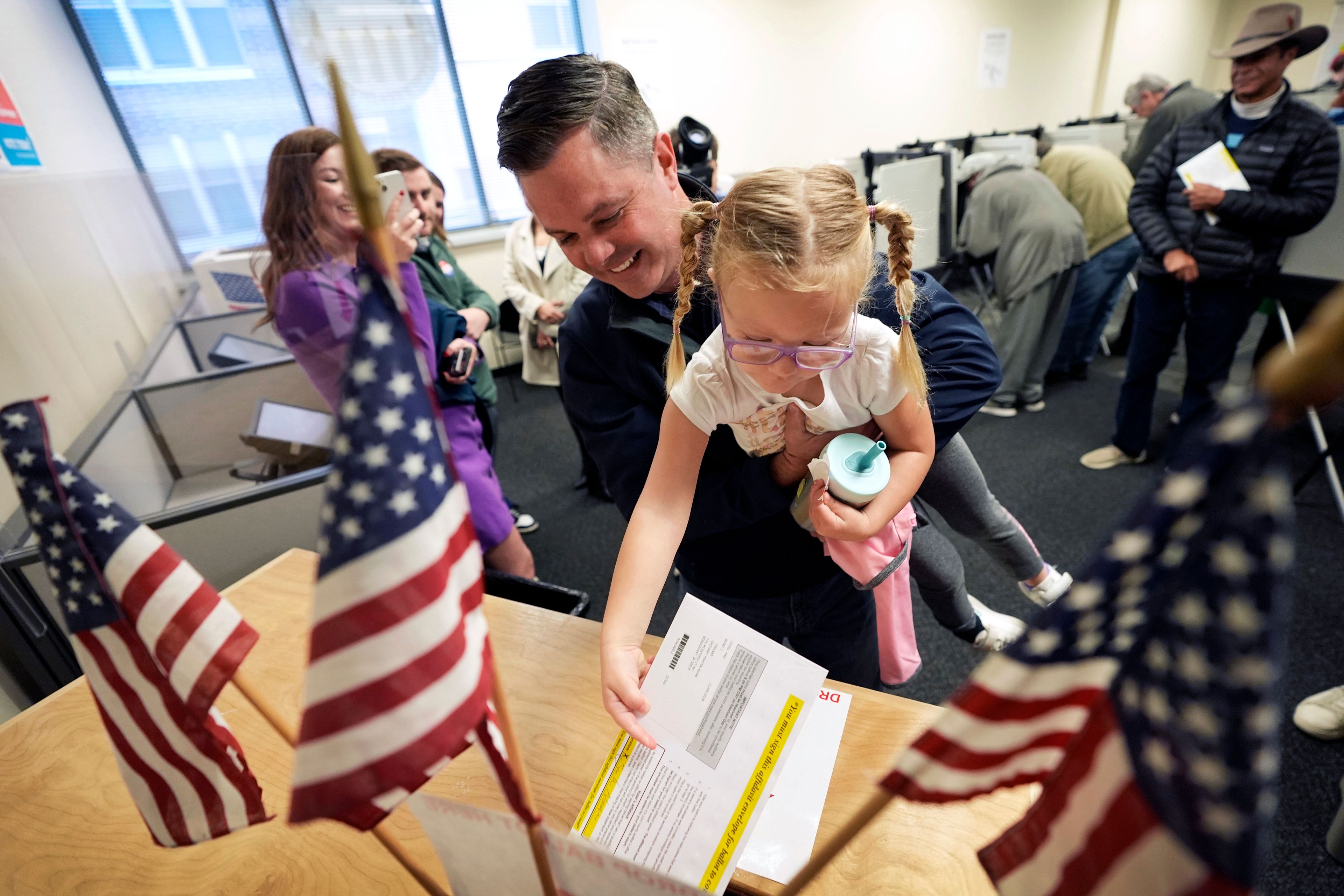 Rep. Zach Nunn, R-Iowa, holds his daughter Aliya as he casts his ballot during early voting at the Polk County Election Office, Wednesday, Oct. 16, 2024, in Des Moines, Iowa. (AP Photo/Charlie Neibergall)