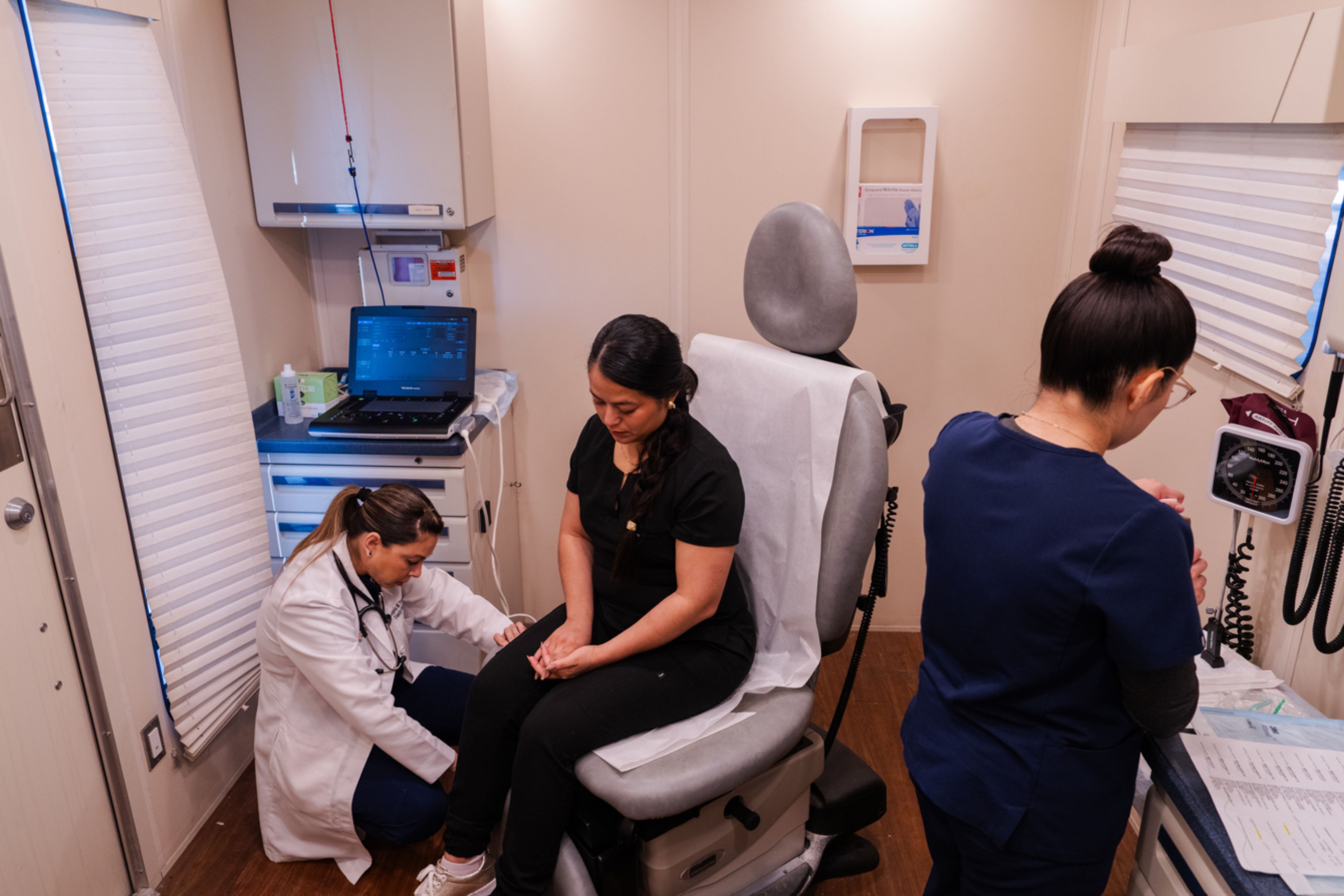 Nurse practitioner Angela Tanguma, left, and medical assistant Adriana Rojas, right, treat Ana Osario in the UniMóvil, a mobile clinic that serves Texas' rural Rio Grande Valley. 