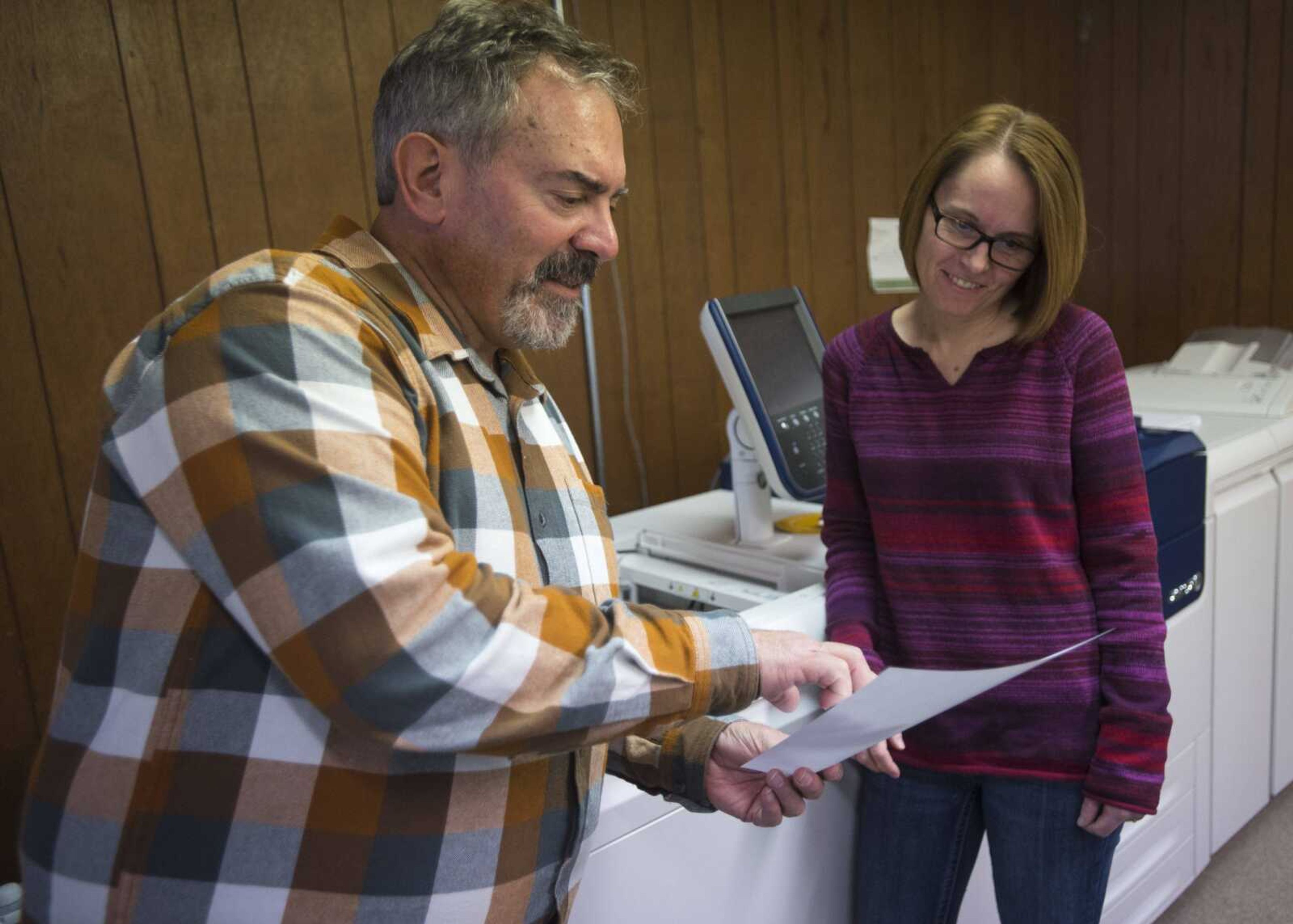 Steve Skelton, left, talks with graphic designer Michelle Ireland at Benchmark Graphics & Printing on Friday.