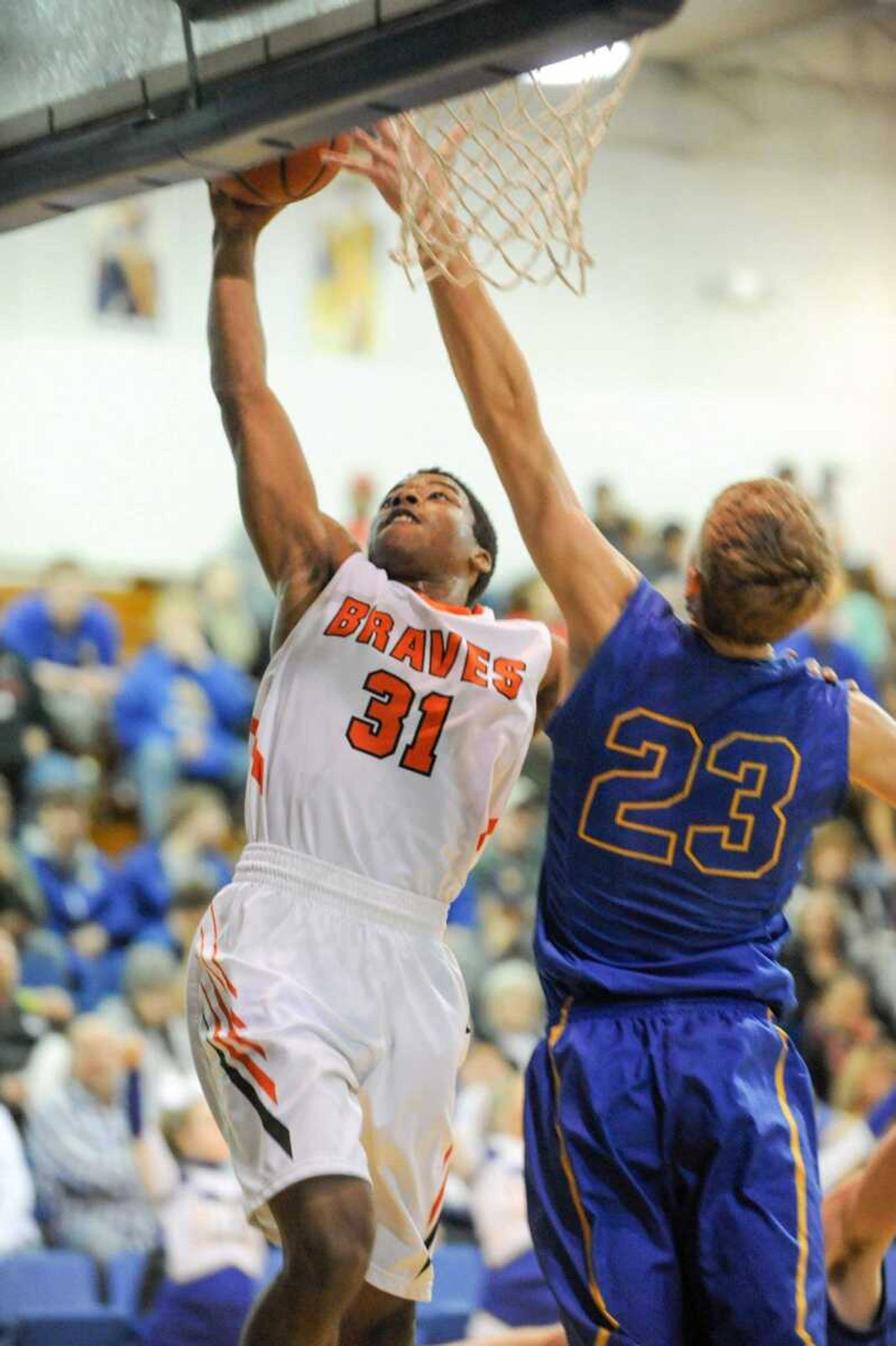 Scott County Central's Jeffery Porter drives to the hoop past Oran's Max Priggel during the second quarter of a semifinal game in the Scott-Mississippi Conference Tournament on Thursday in Scott City. The Braves won 73-56.