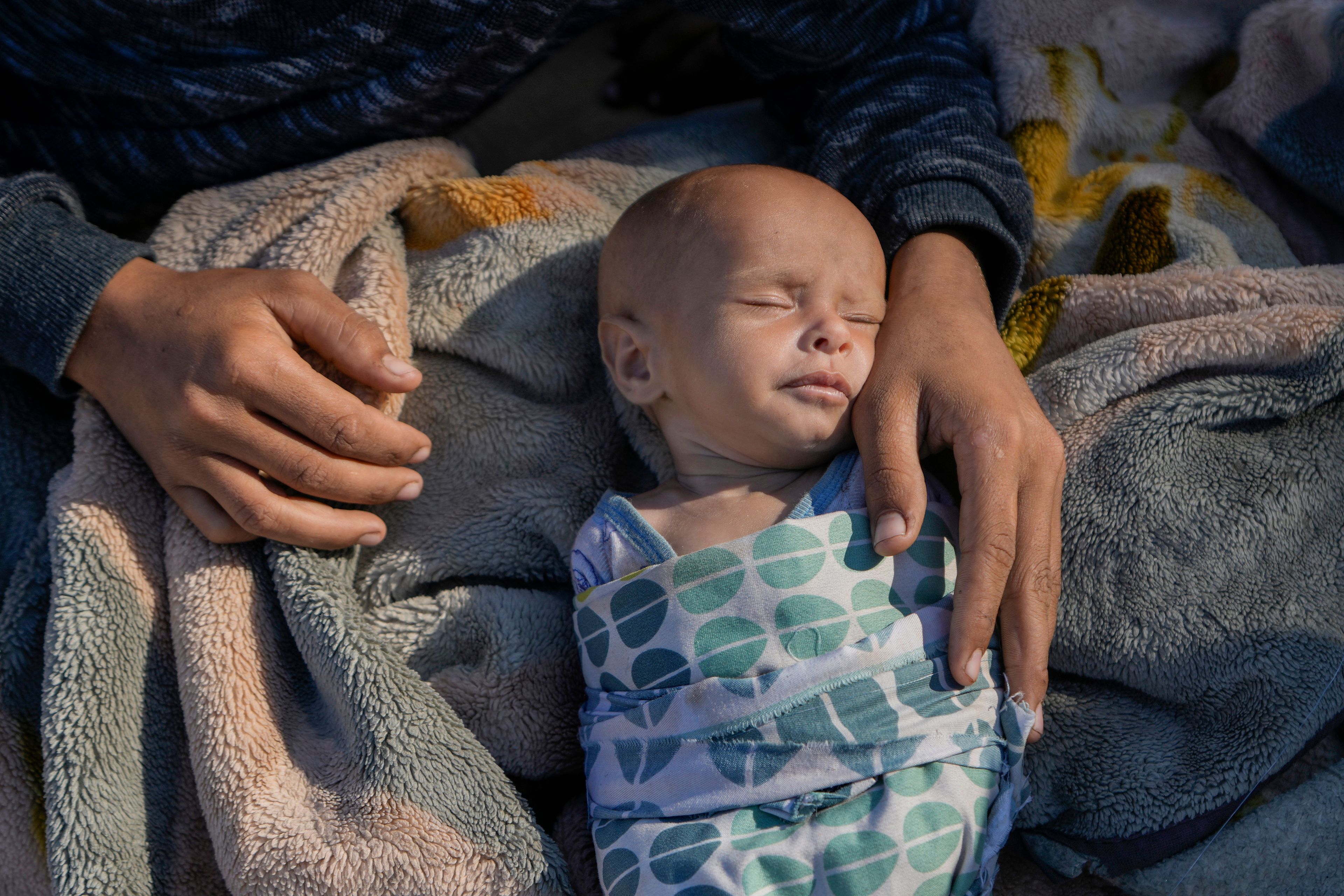 A woman cares for her newborn girl, Fatima, in Beirut's Martyrs' square after fleeing the Israeli airstrikes in the southern suburbs of Dahiyeh, Sunday, Sept. 29, 2024. (AP Photo/Bilal Hussein)