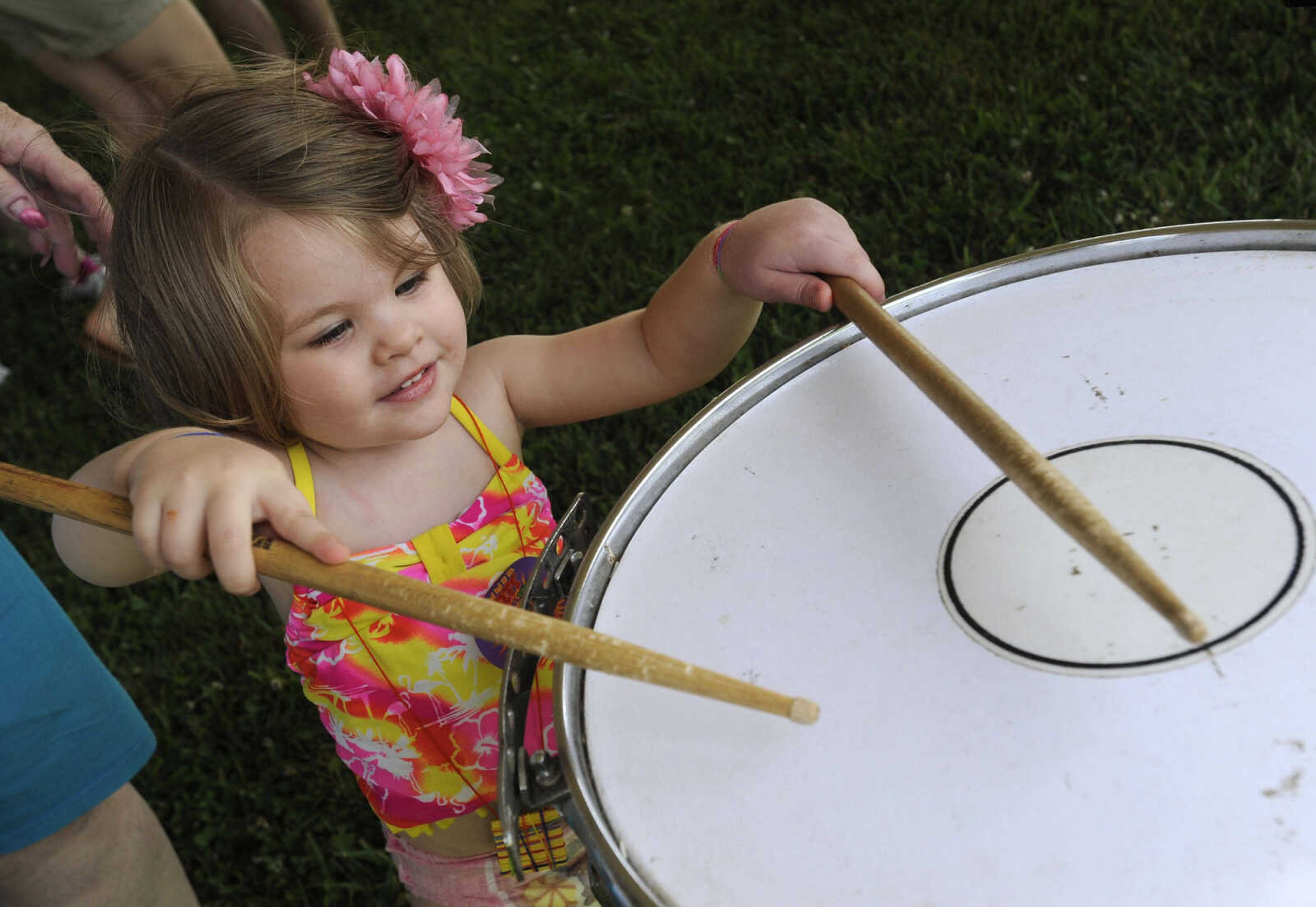 Amberlynn Nation tries out a snare drum in the art tent Saturday, June 21, 2014 at the River Campus Summer Arts Festival in Cape Girardeau.