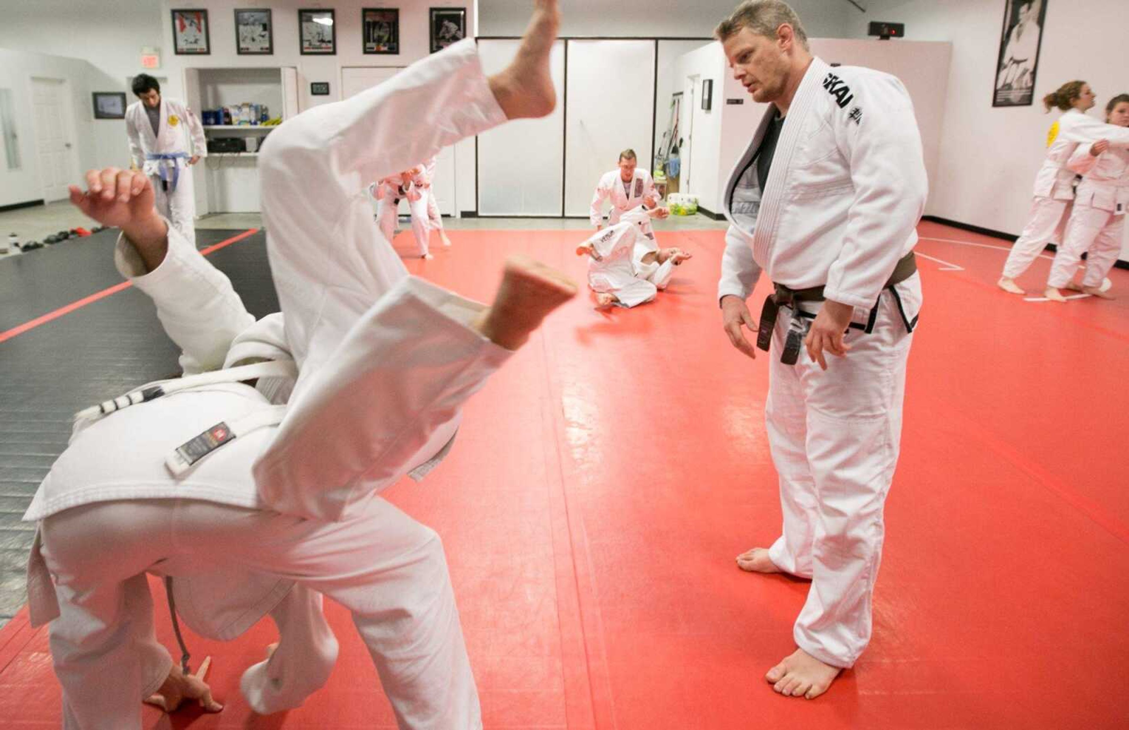 Brian Imholz watches as students practice a takedown tactic during a fundamentals class Tuesday at Gracie Jiu-Jitsu of Southeast Missouri in Jackson. (Glenn Landberg)