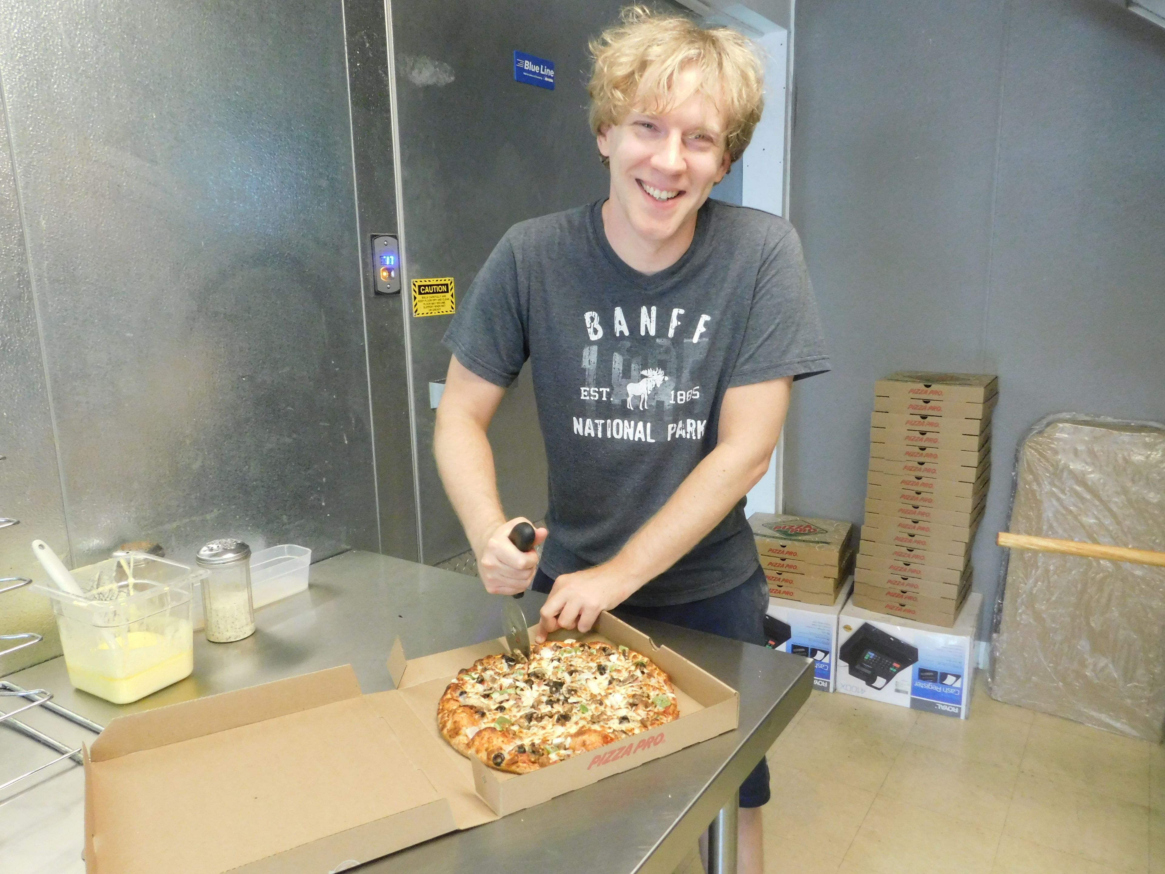 Alex Ballance cuts a customer's pizza at Pizza Pro in Scott City. The restaurant has been open for just over a year, but Ballance has a dozen years of experience in the pizza industry. 