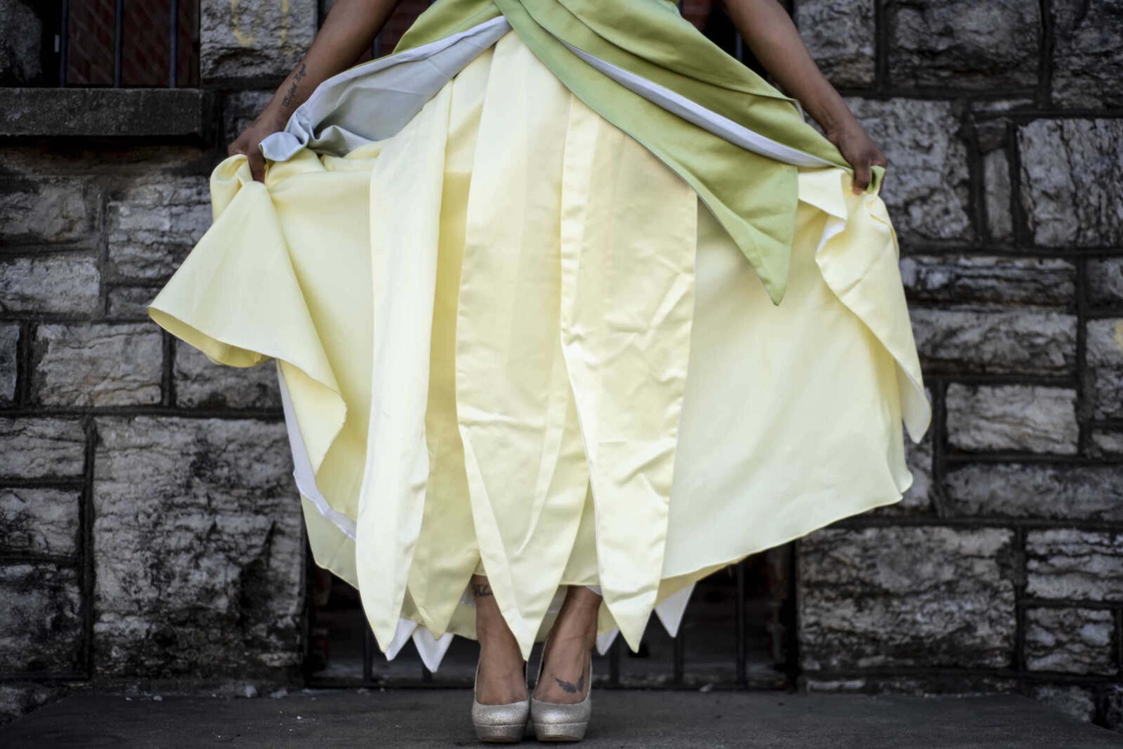 Kaleisha Walker holds out her dress as she portrays the role of Tiana from Disney's "The Princess and the Frog" at Fort D Thursday, March 21, 2019, in Cape Girardeau.