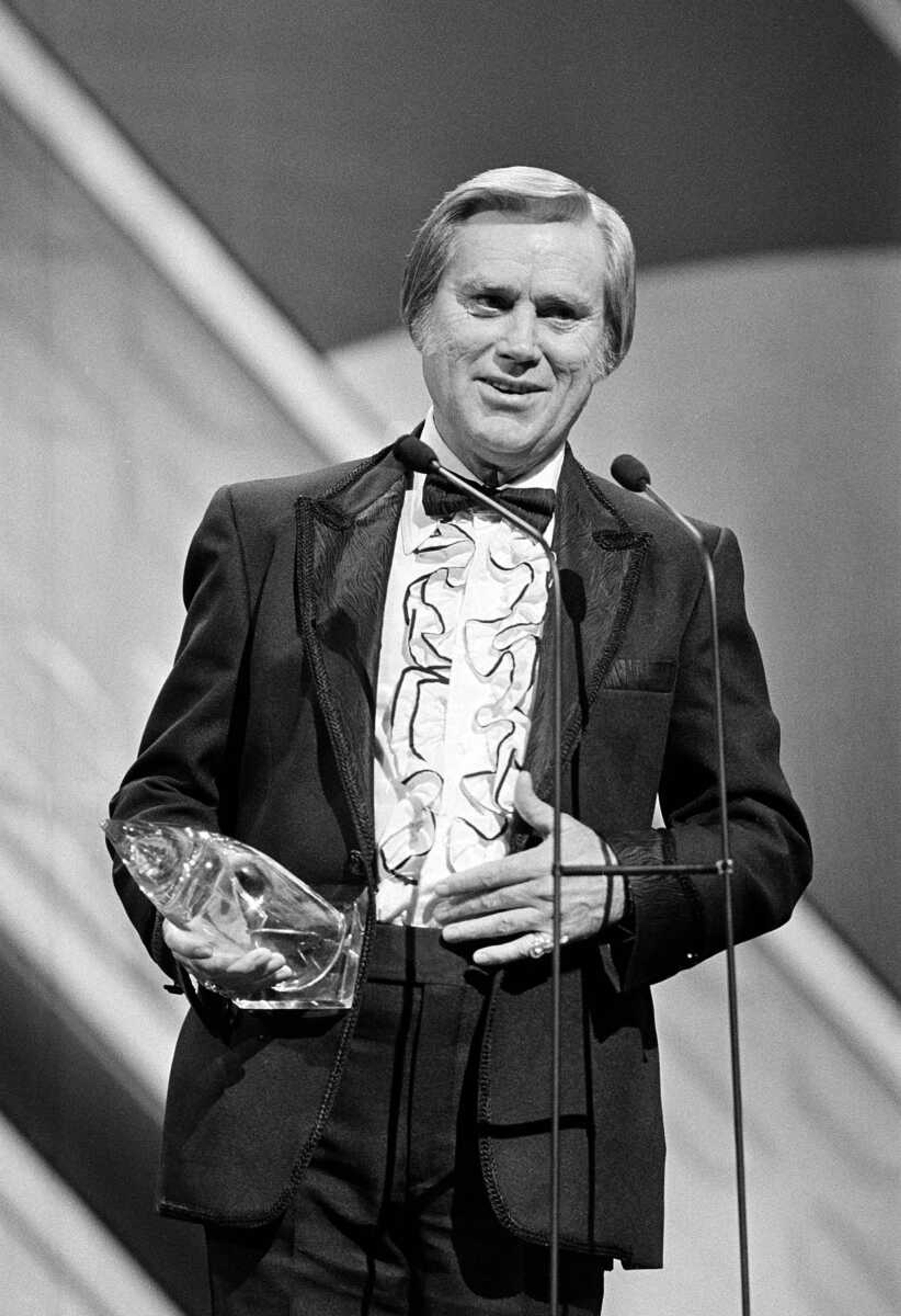 FILE - In this Oct. 1986 file photo,   George Jones accepts his 1985 award at the Country Music Association (CMA) awards show in Nashville, Tenn.   Jones, the peerless, hard-living country singer who recorded dozens of hits about good times and regrets and peaked with the heartbreaking classic "He Stopped Loving Her Today," has died. He was 81. Jones died Friday, April 26, 2013 at Vanderbilt University Medical Center in Nashville after being hospitalized with fever and irregular blood pressure, according to his publicist Kirt Webster.  (AP Photo, file)